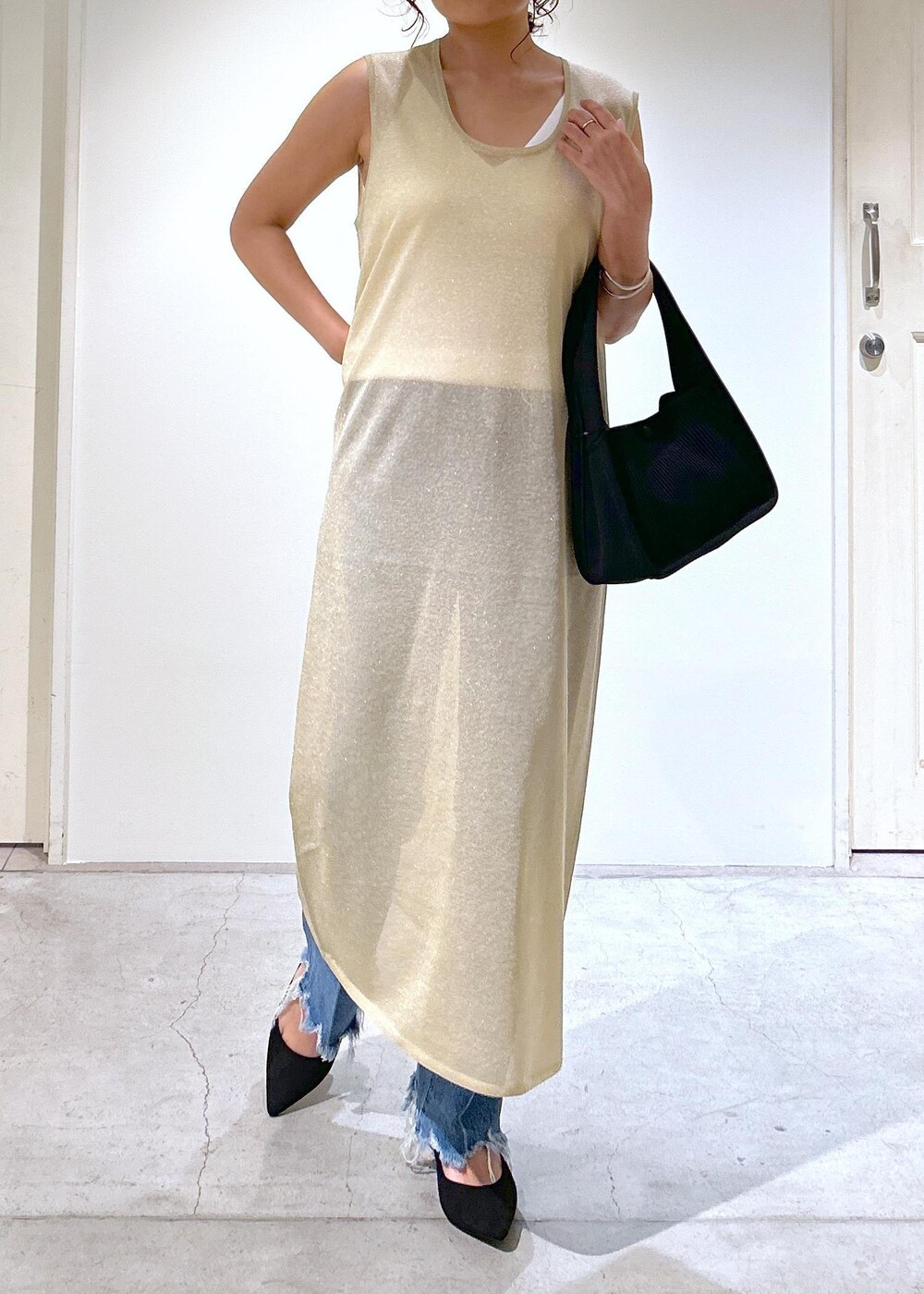 ゴールド系のワンピース、ホワイト系のキャミソール、ブルー系のデニムパンツを着用したレディースの夏コーディネートの9枚目の写真