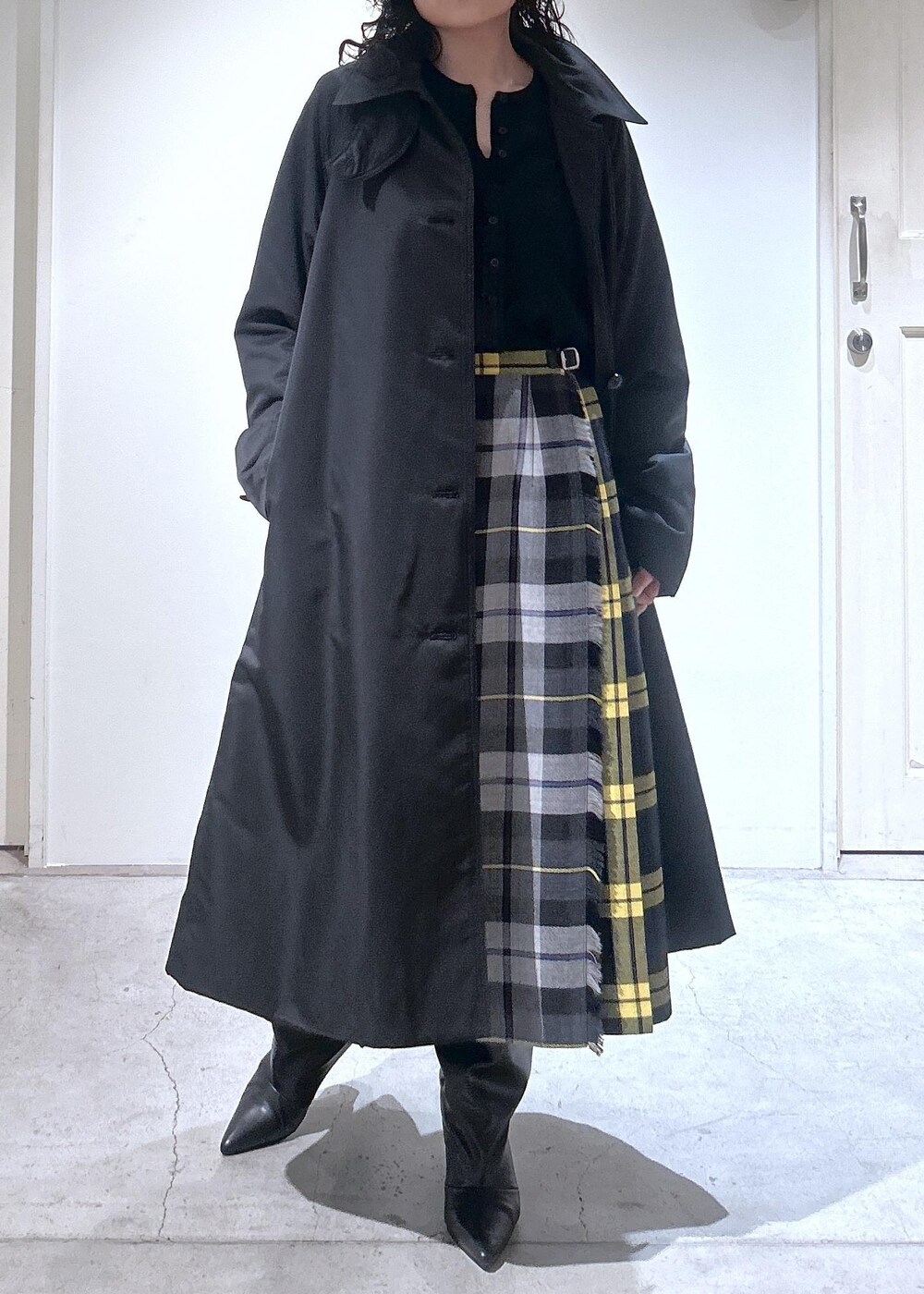 ブラック系のカーディガン/ボレロ、グレー系のスカート、ブラック系のダウンジャケット/コートを着用したレディースの秋コーディネートの8枚目の写真