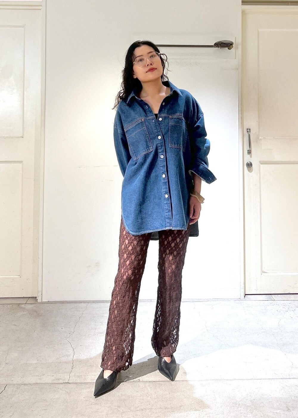 ブラウン系のショルダーバッグ、ブルー系のシャツ/ブラウス、ブラック系のパンプスを着用したレディースの秋コーディネートの3枚目の写真