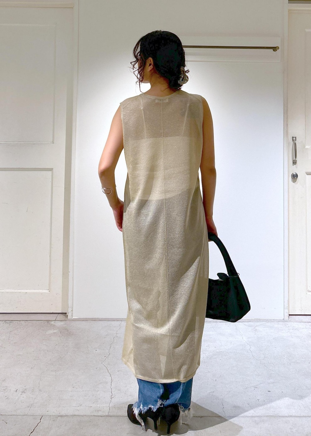 ゴールド系のワンピース、ホワイト系のキャミソール、ブルー系のデニムパンツを着用したレディースの夏コーディネートの6枚目の写真