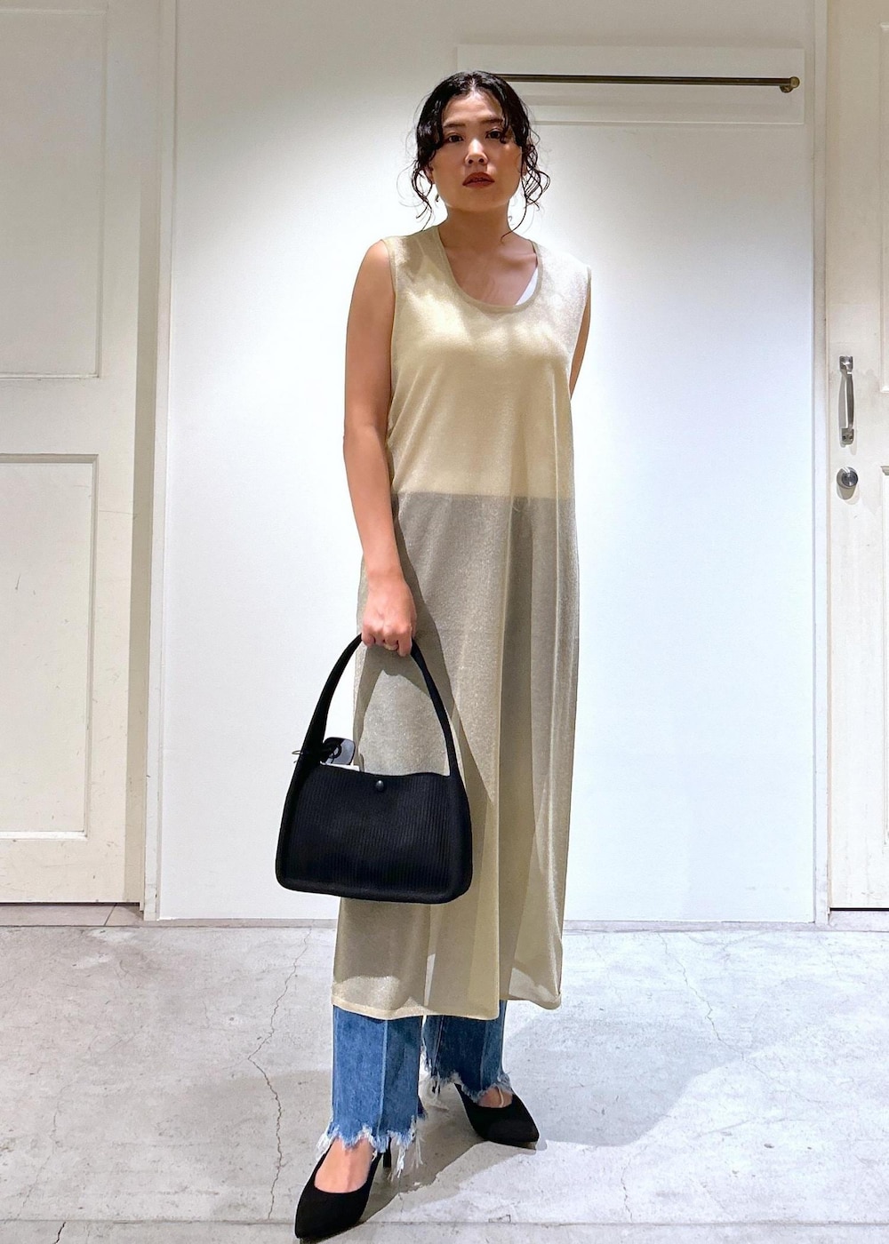 ゴールド系のワンピース、ホワイト系のキャミソール、ブルー系のデニムパンツを着用したレディースの夏コーディネートの2枚目の写真