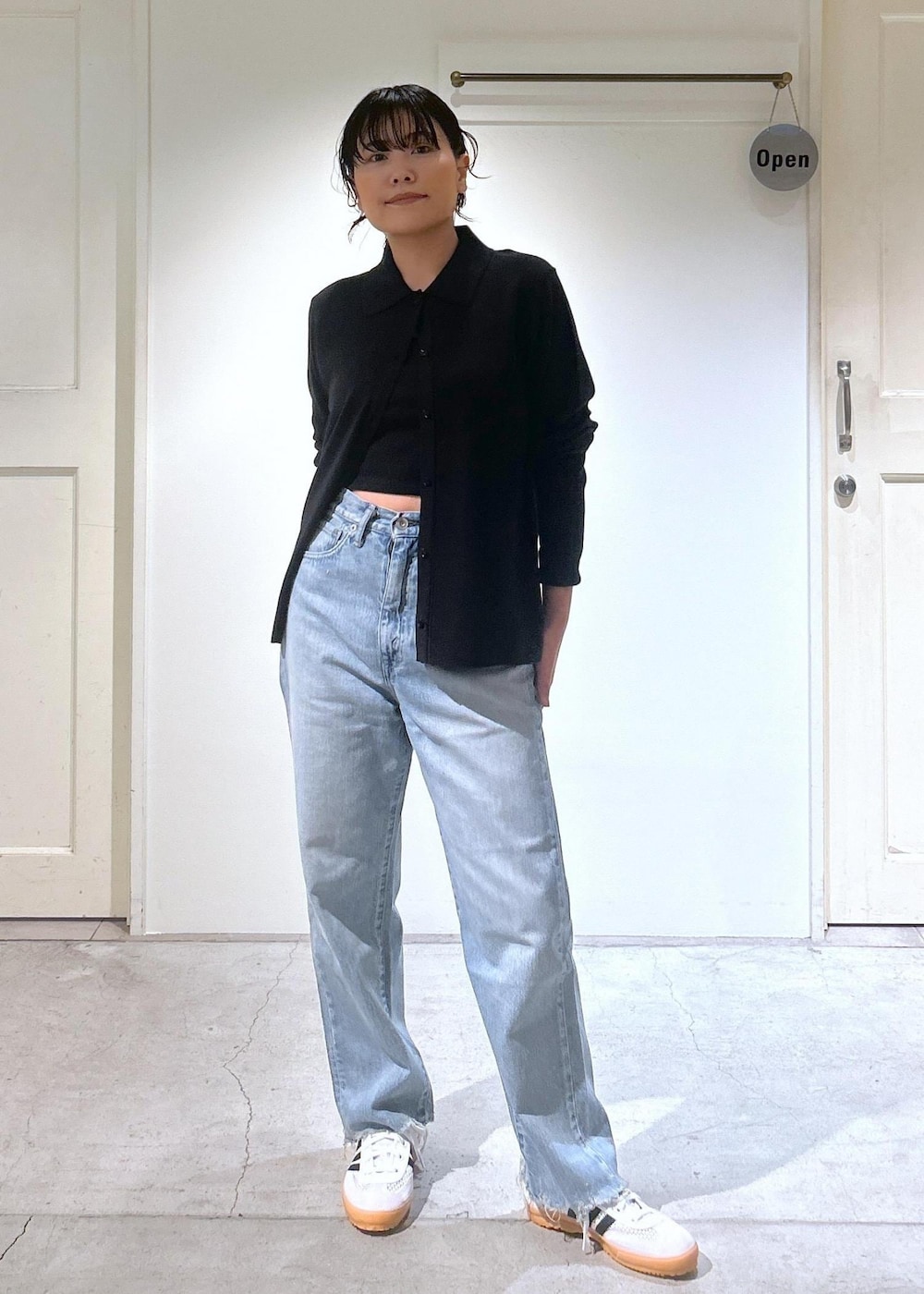 ブラック系のカーディガン/ボレロ、ホワイト系のスニーカー、ブルー系のデニムパンツを着用したレディースの夏コーディネートの5枚目の写真