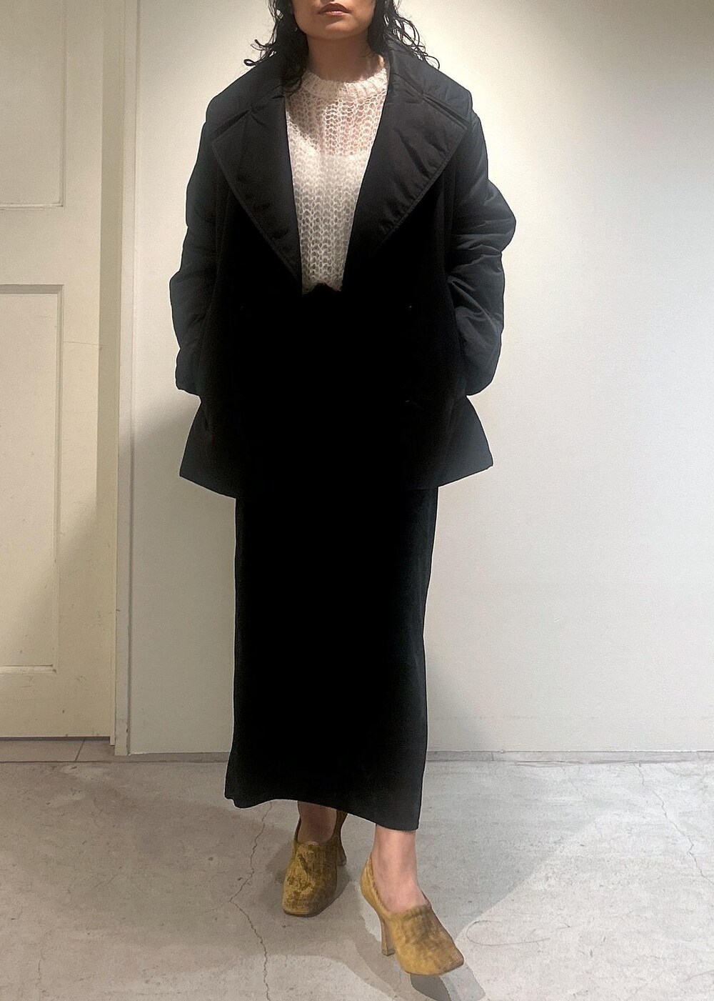 ブラック系のスカート、ブラック系のダウンジャケット/コートを着用したレディースの秋コーディネートの7枚目の写真