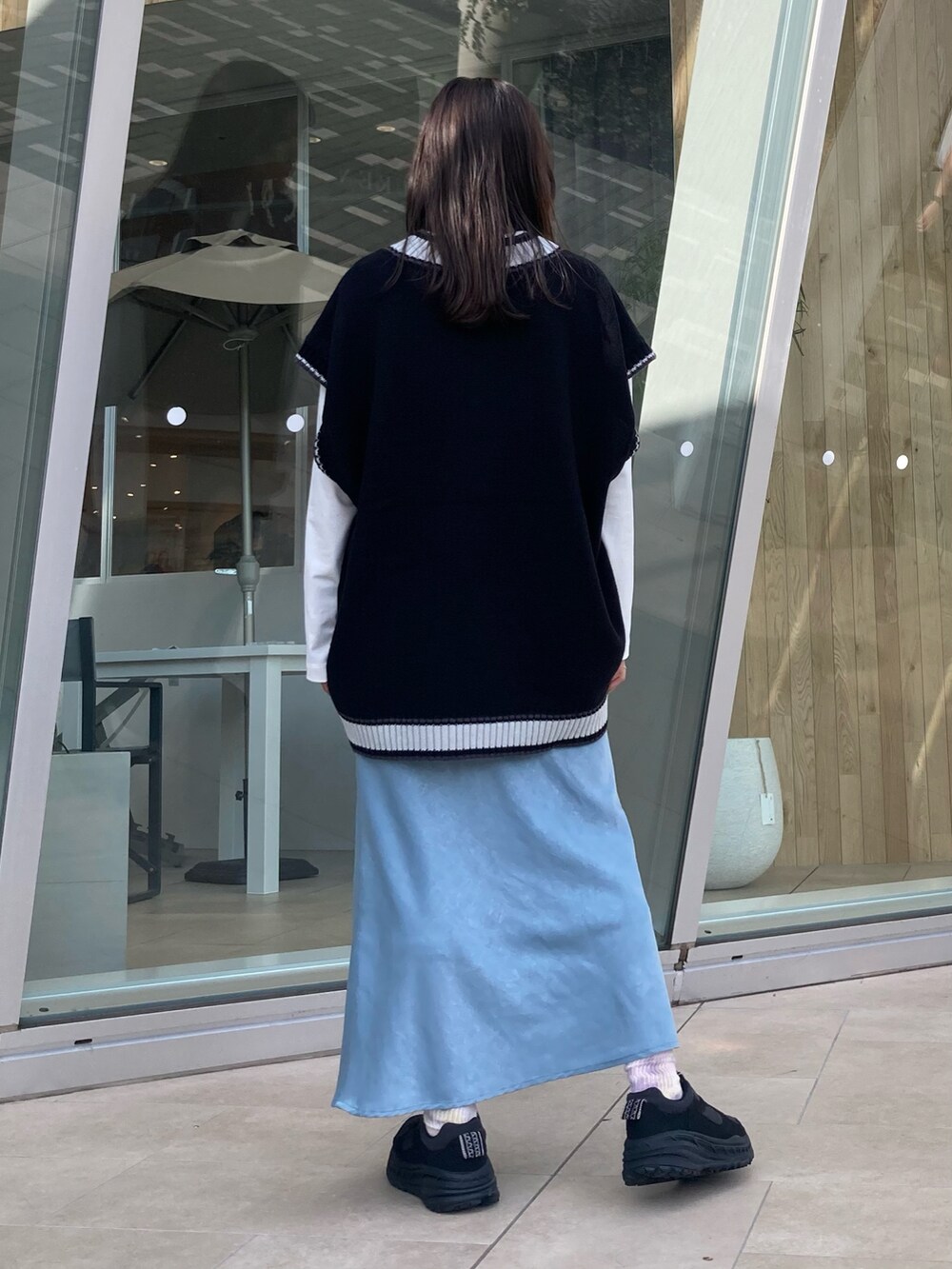 ブラック系のベストを着用したレディースの秋コーディネートの2枚目の写真