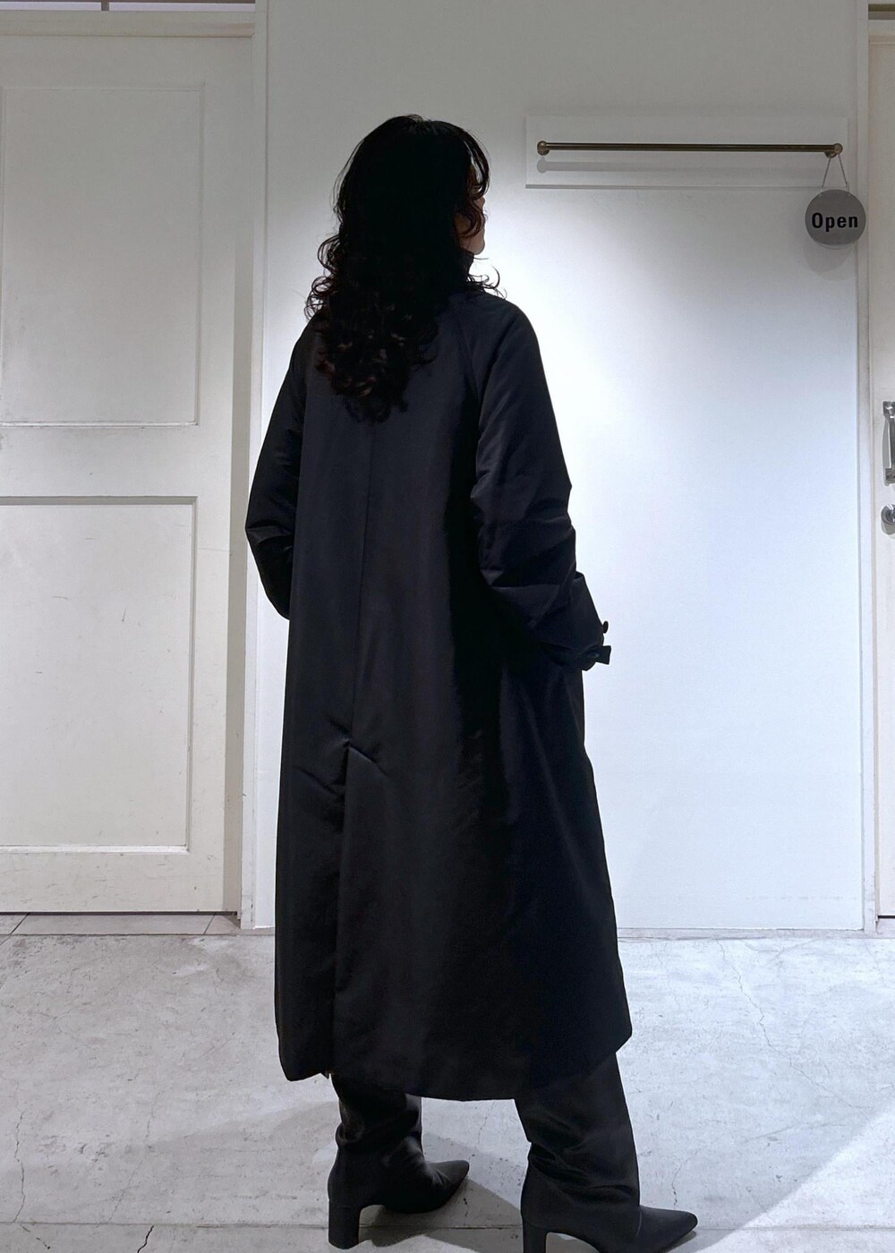 ブラック系のカーディガン/ボレロ、グレー系のスカート、ブラック系のダウンジャケット/コートを着用したレディースの秋コーディネートの6枚目の写真