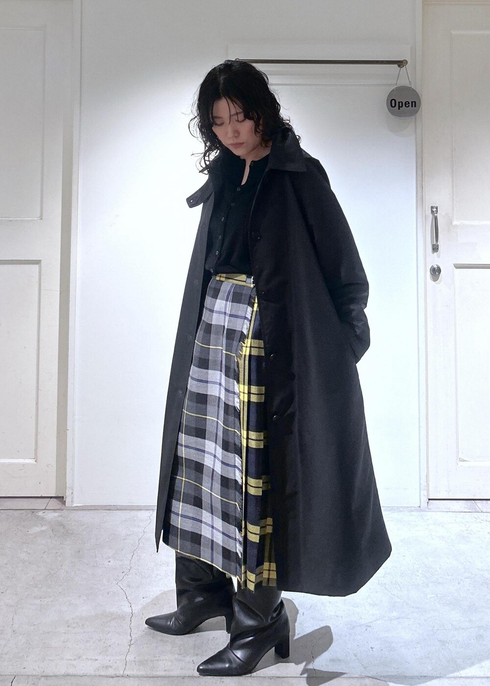 ブラック系のカーディガン/ボレロ、グレー系のスカート、ブラック系のダウンジャケット/コートを着用したレディースの秋コーディネートの3枚目の写真