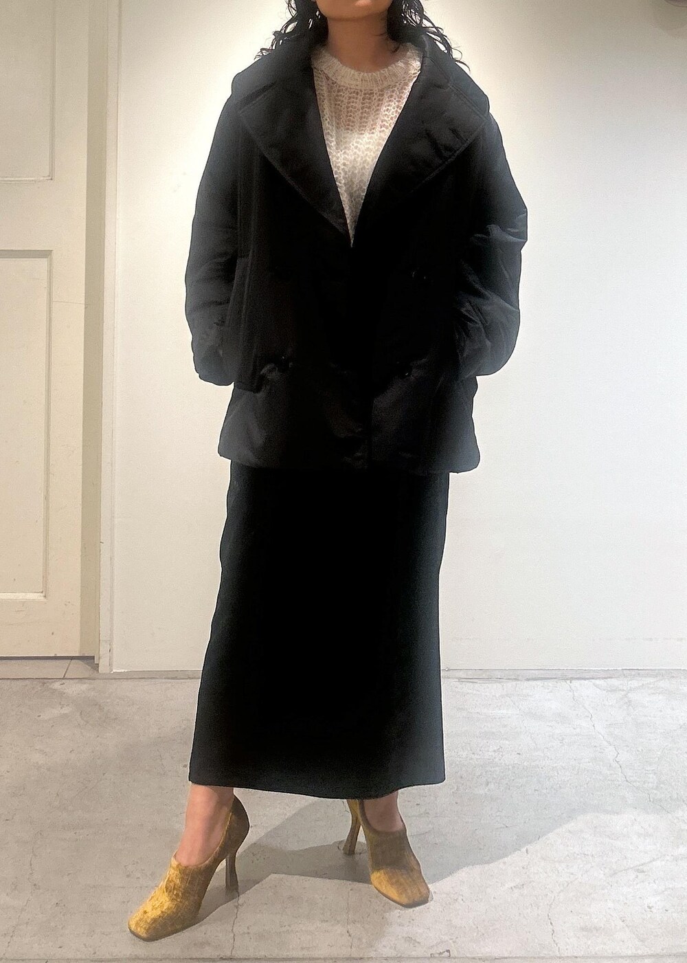 ブラック系のスカート、ブラック系のダウンジャケット/コートを着用したレディースの秋コーディネートの6枚目の写真