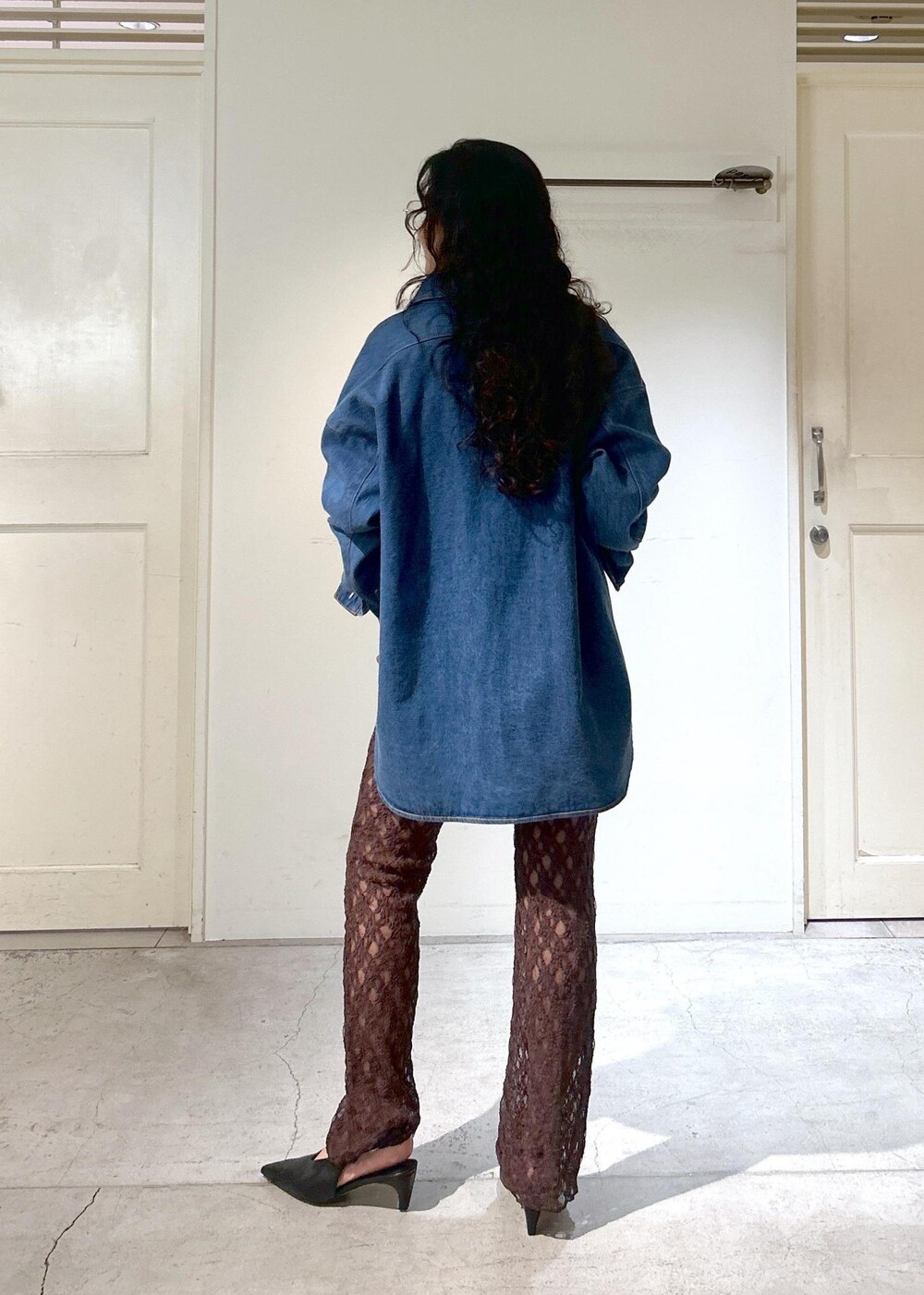 ブラウン系のショルダーバッグ、ブルー系のシャツ/ブラウス、ブラック系のパンプスを着用したレディースの秋コーディネートの5枚目の写真