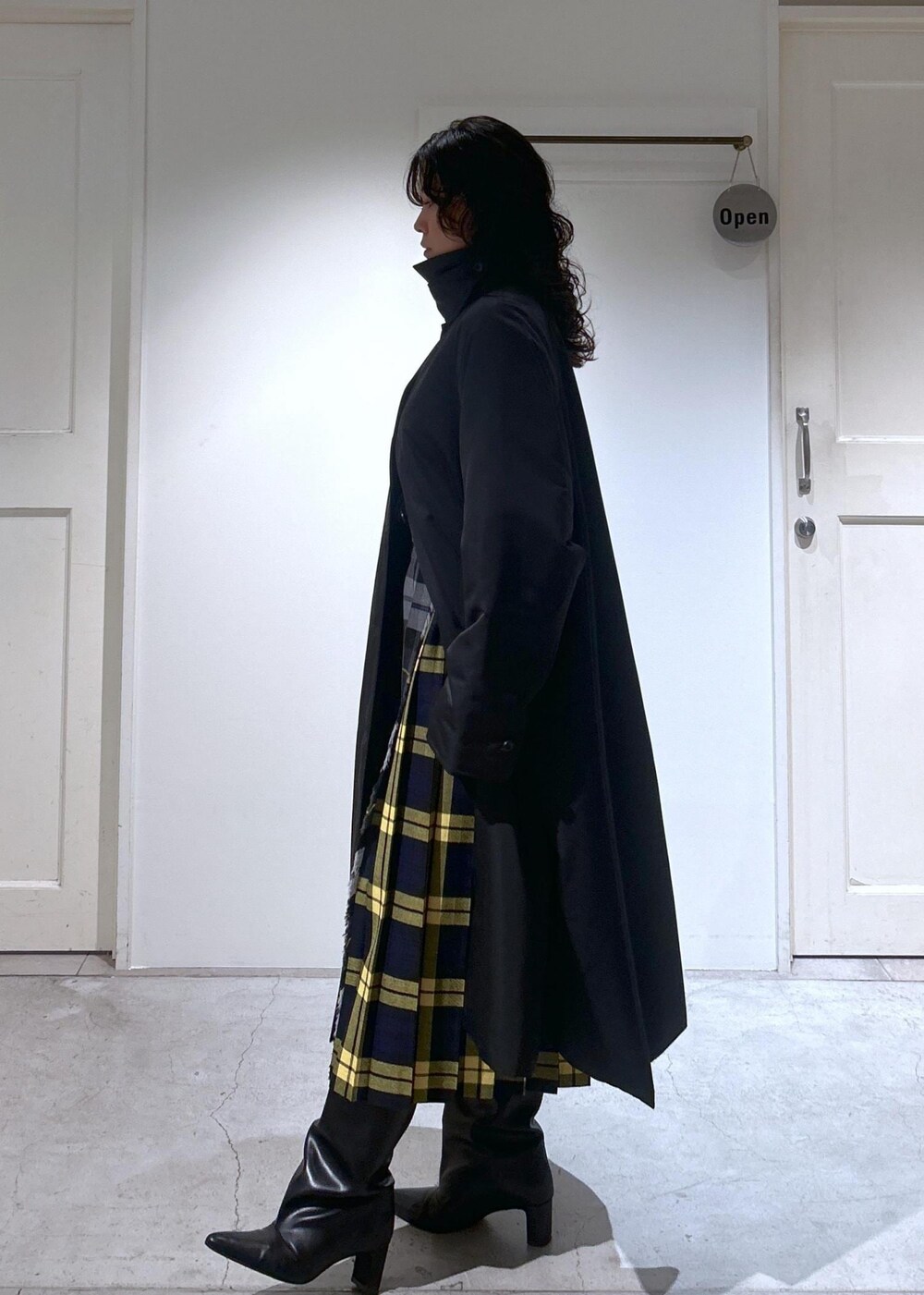 ブラック系のカーディガン/ボレロ、グレー系のスカート、ブラック系のダウンジャケット/コートを着用したレディースの秋コーディネートの7枚目の写真