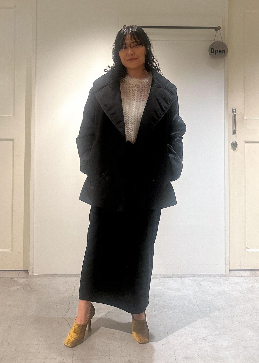 ブラック系のスカート、ブラック系のダウンジャケット/コートを着用したレディースの秋コーディネートの5枚目の写真