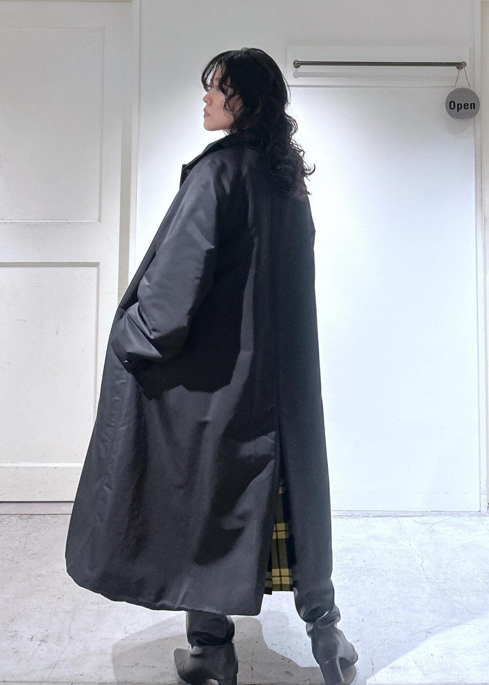 ブラック系のカーディガン/ボレロ、グレー系のスカート、ブラック系のダウンジャケット/コートを着用したレディースの秋コーディネートの5枚目の写真