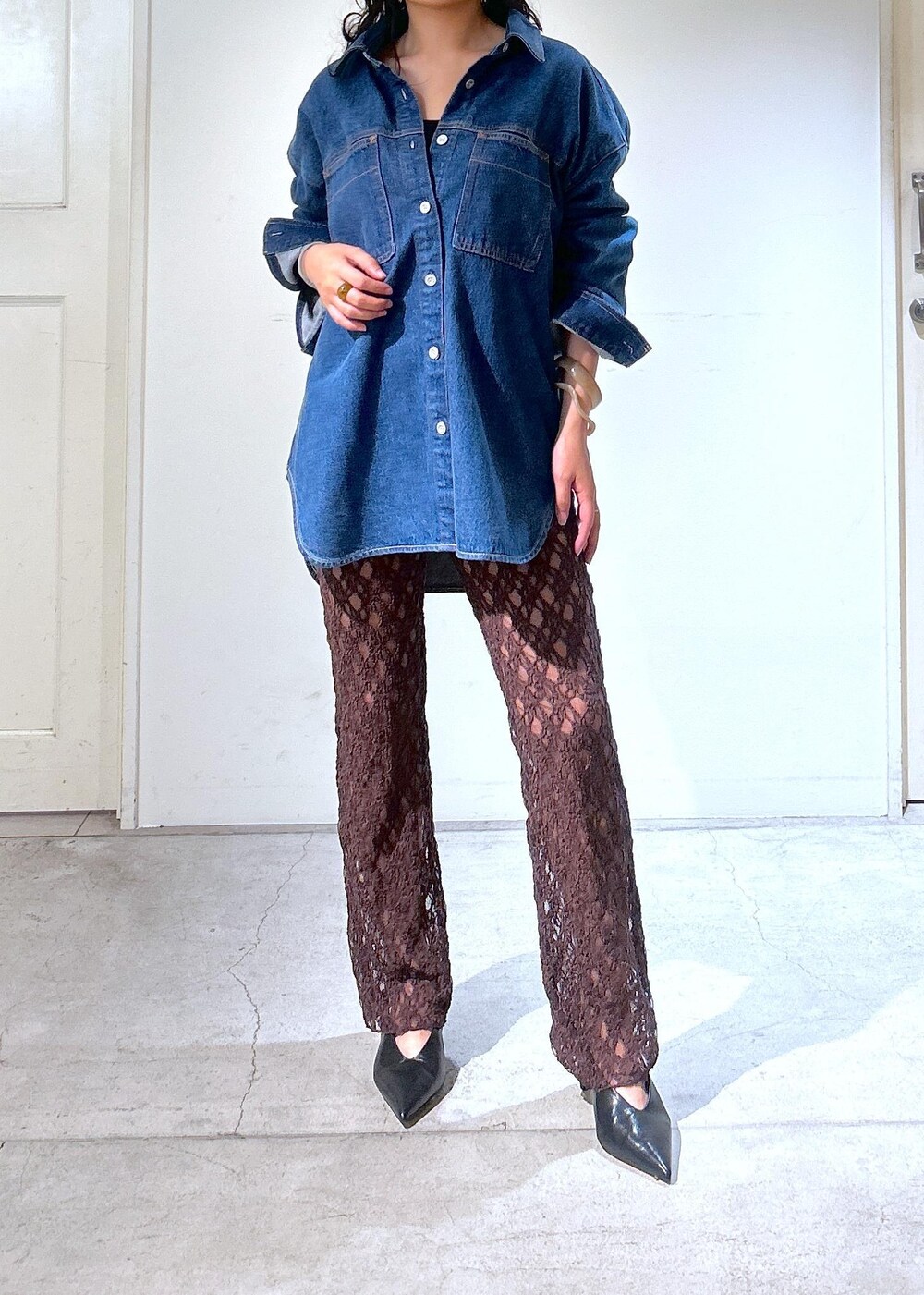 ブラウン系のショルダーバッグ、ブルー系のシャツ/ブラウス、ブラック系のパンプスを着用したレディースの秋コーディネートの6枚目の写真