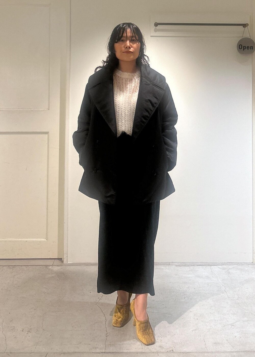 ブラック系のスカート、ブラック系のダウンジャケット/コートを着用したレディースの秋コーディネートの2枚目の写真