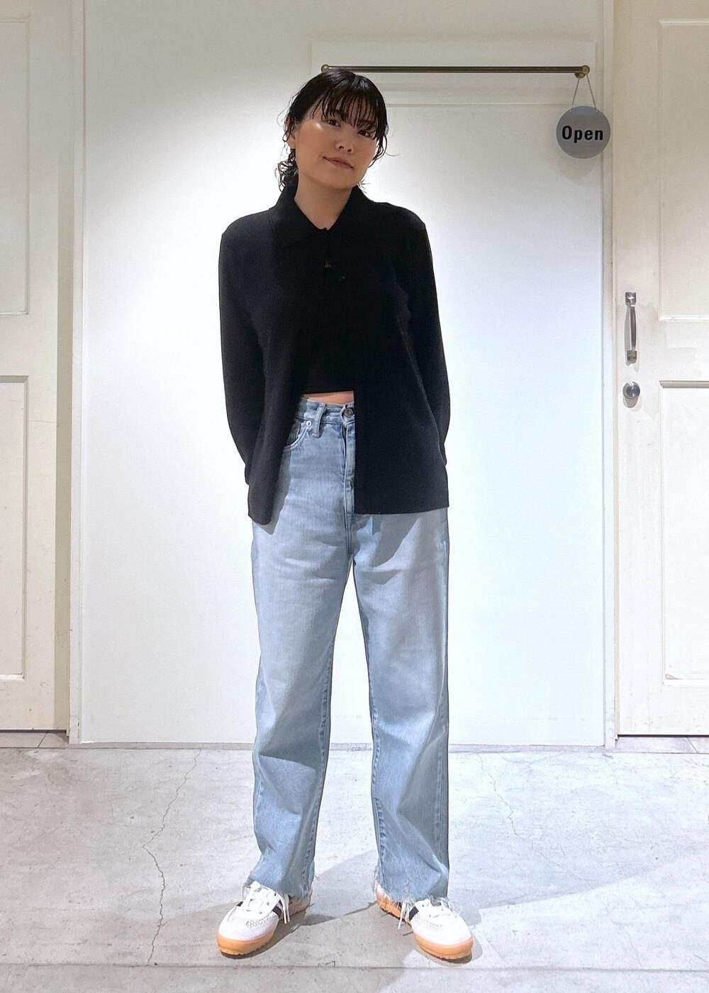 ブラック系のカーディガン/ボレロ、ホワイト系のスニーカー、ブルー系のデニムパンツを着用したレディースの夏コーディネートの7枚目の写真