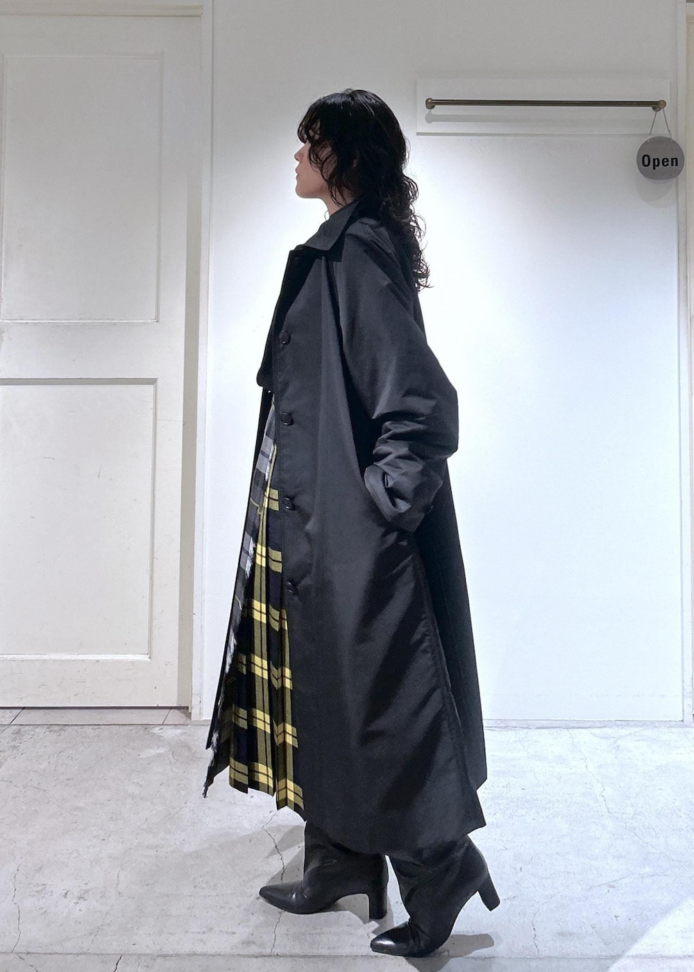 ブラック系のカーディガン/ボレロ、グレー系のスカート、ブラック系のダウンジャケット/コートを着用したレディースの秋コーディネートの4枚目の写真