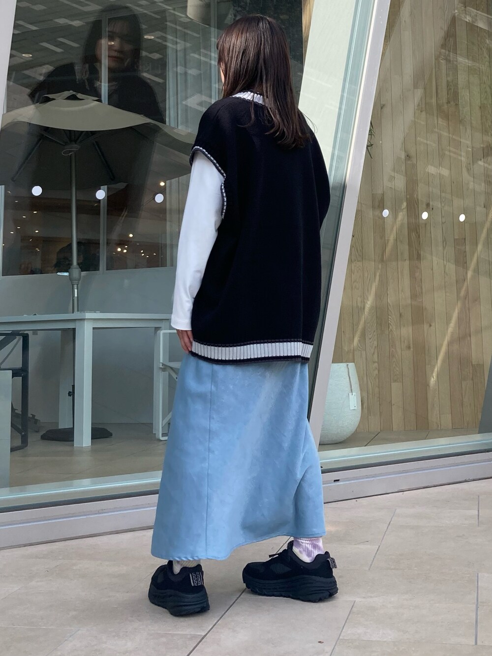 ブラック系のベストを着用したレディースの秋コーディネートの3枚目の写真