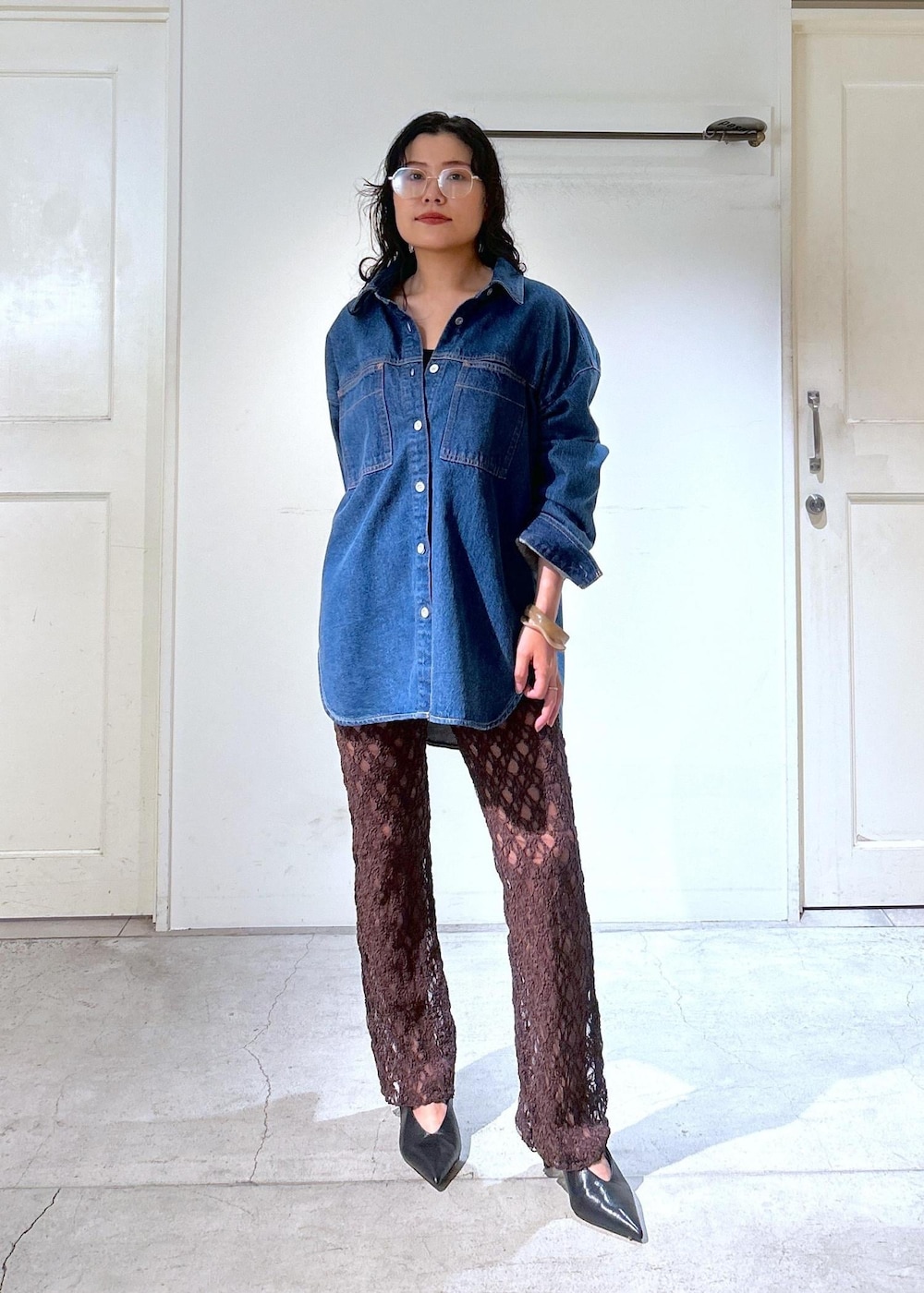 ブラウン系のショルダーバッグ、ブルー系のシャツ/ブラウス、ブラック系のパンプスを着用したレディースの秋コーディネートの2枚目の写真