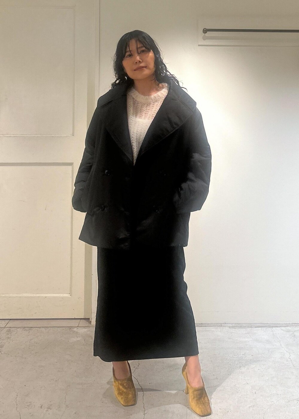 ブラック系のスカート、ブラック系のダウンジャケット/コートを着用したレディースの秋コーディネートの4枚目の写真