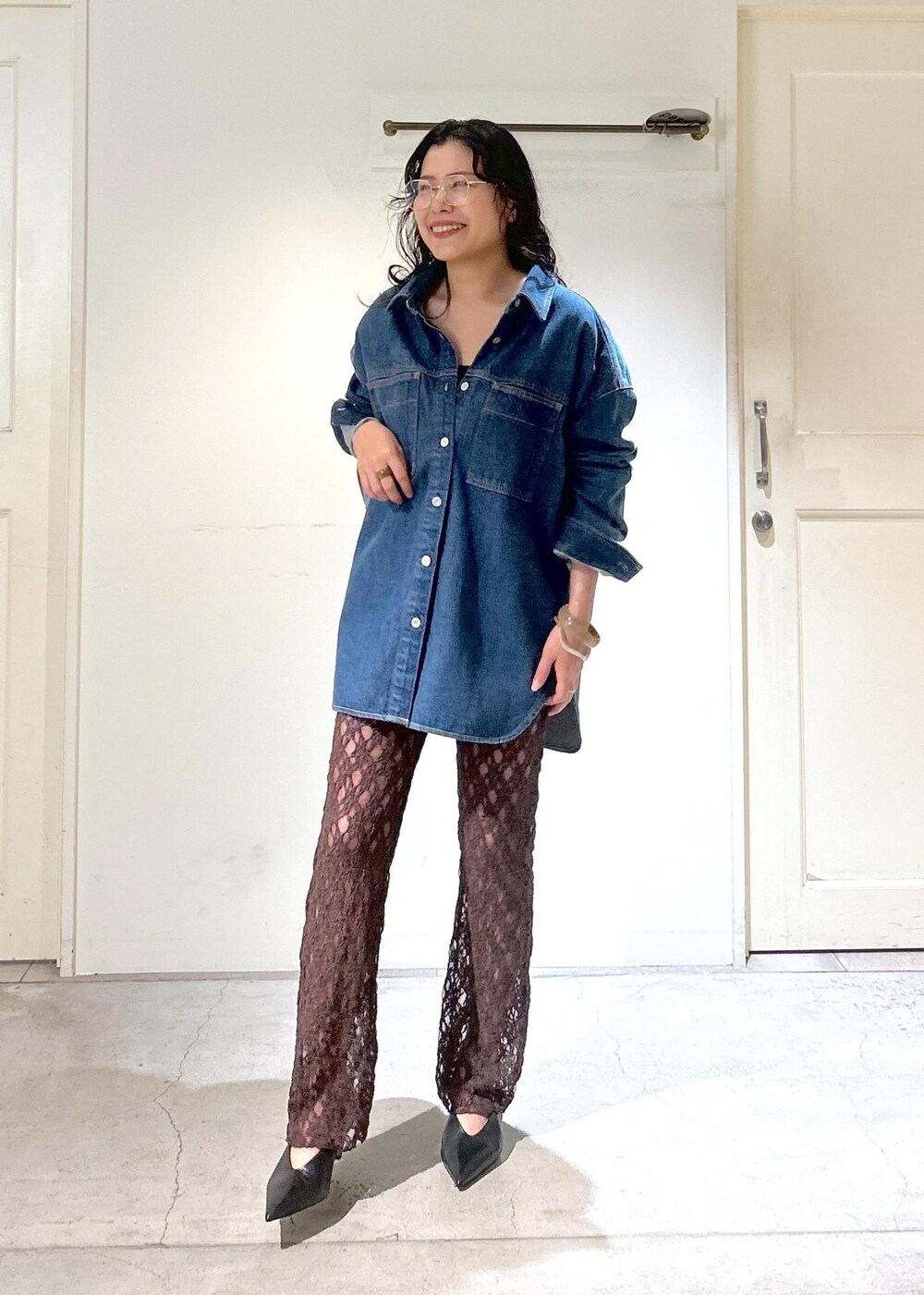 ブラウン系のショルダーバッグ、ブルー系のシャツ/ブラウス、ブラック系のパンプスを着用したレディースの秋コーディネートの4枚目の写真