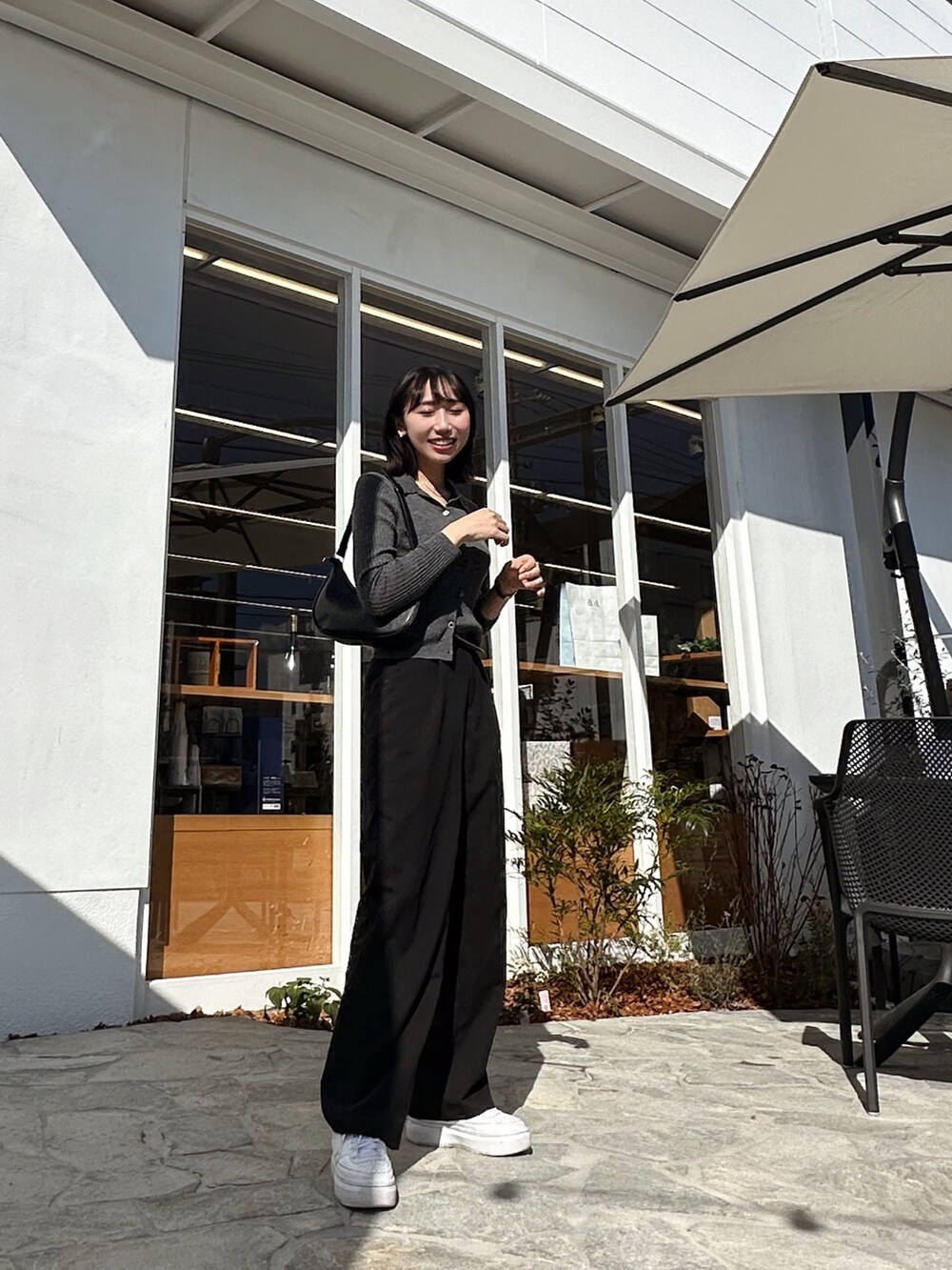 グレー系のトップスを着用したレディースの秋コーディネートの2枚目の写真