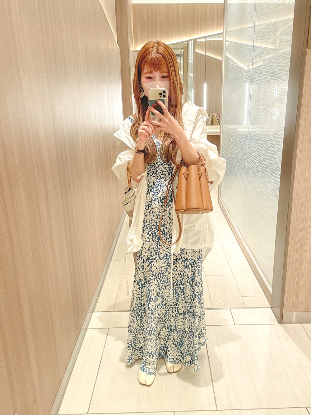 ブルー系のワンピース/ドレス、ブラウン系のバッグ、ホワイト系のブーツを着用したレディースの春コーディネートの2枚目の写真