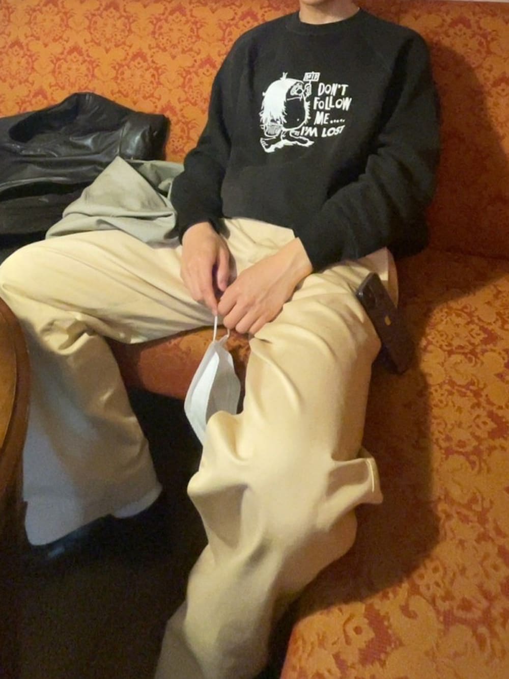 ベージュ系のチノパンツ、ブラウン系のダウンベスト、ブラック系のスウェットを着用したメンズの夏コーディネートの3枚目の写真