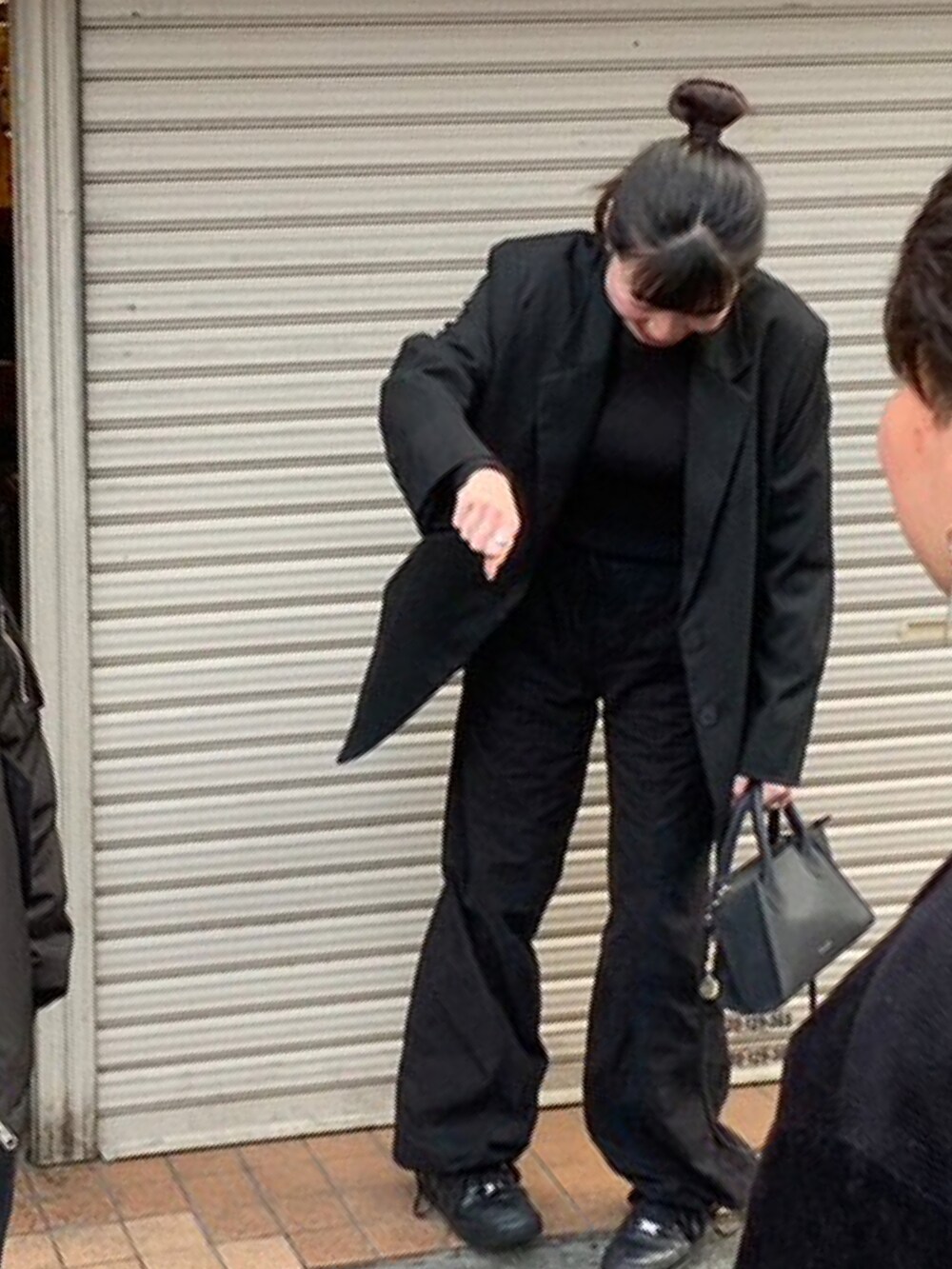 ブラック系のニット/セーター、ブラック系のテーラードジャケット、ブラック系のカーゴパンツを着用したレディースの春コーディネートの2枚目の写真