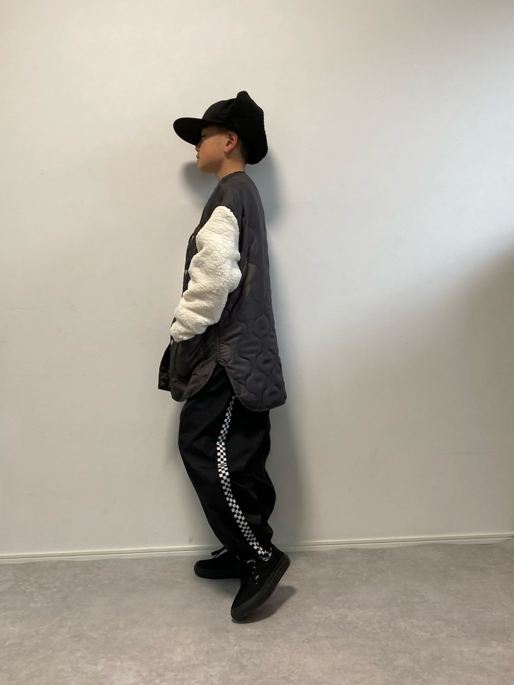 ブラック系のノーカラージャケット、ブラック系のパンツ、ブラック系のキャップを着用したキッズの冬コーディネートの2枚目の写真