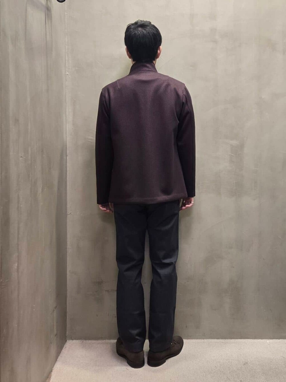 レッド系のブルゾン、グレー系のスラックスを着用したメンズの秋コーディネートの3枚目の写真