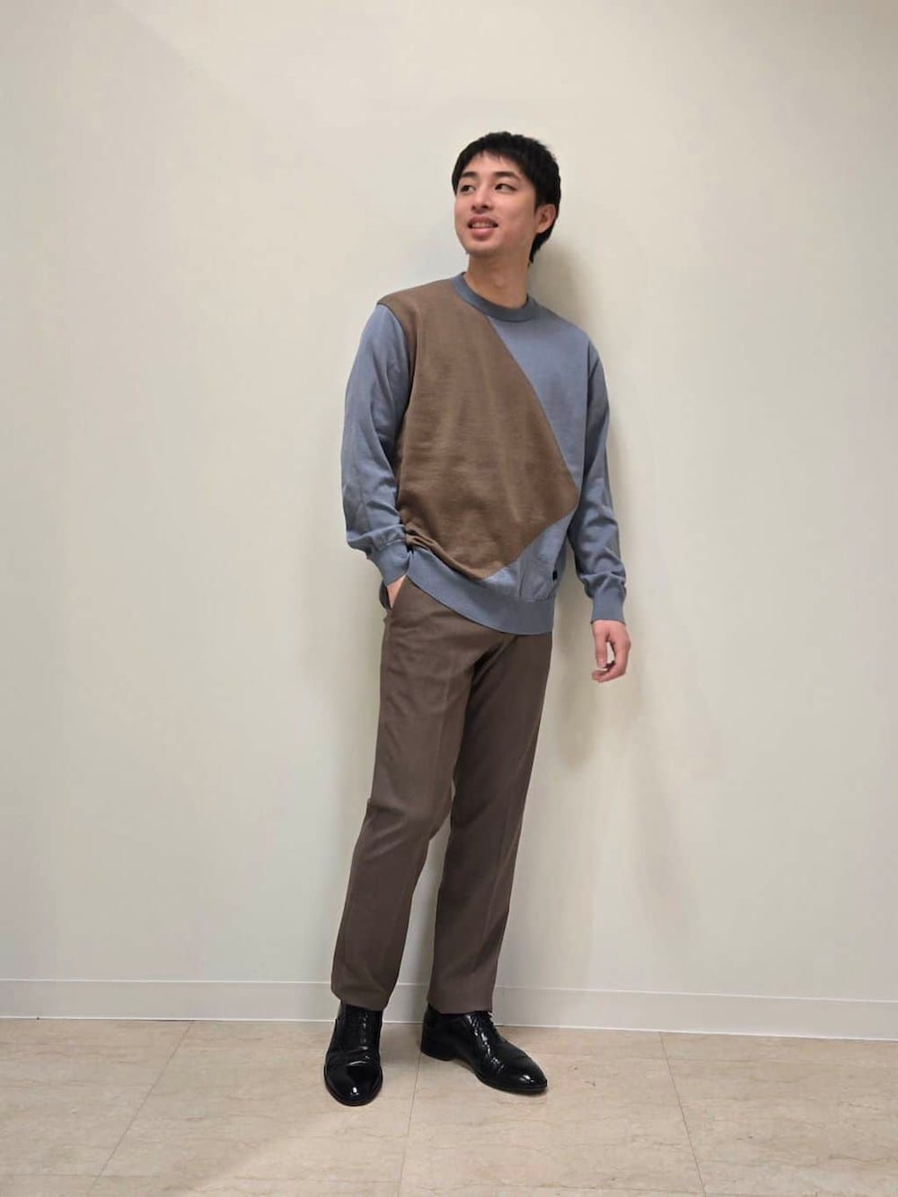ベージュ系のテーラードジャケット、ベージュ系のスラックス、ブラック系のドレスシューズを着用したメンズの冬コーディネートの7枚目の写真