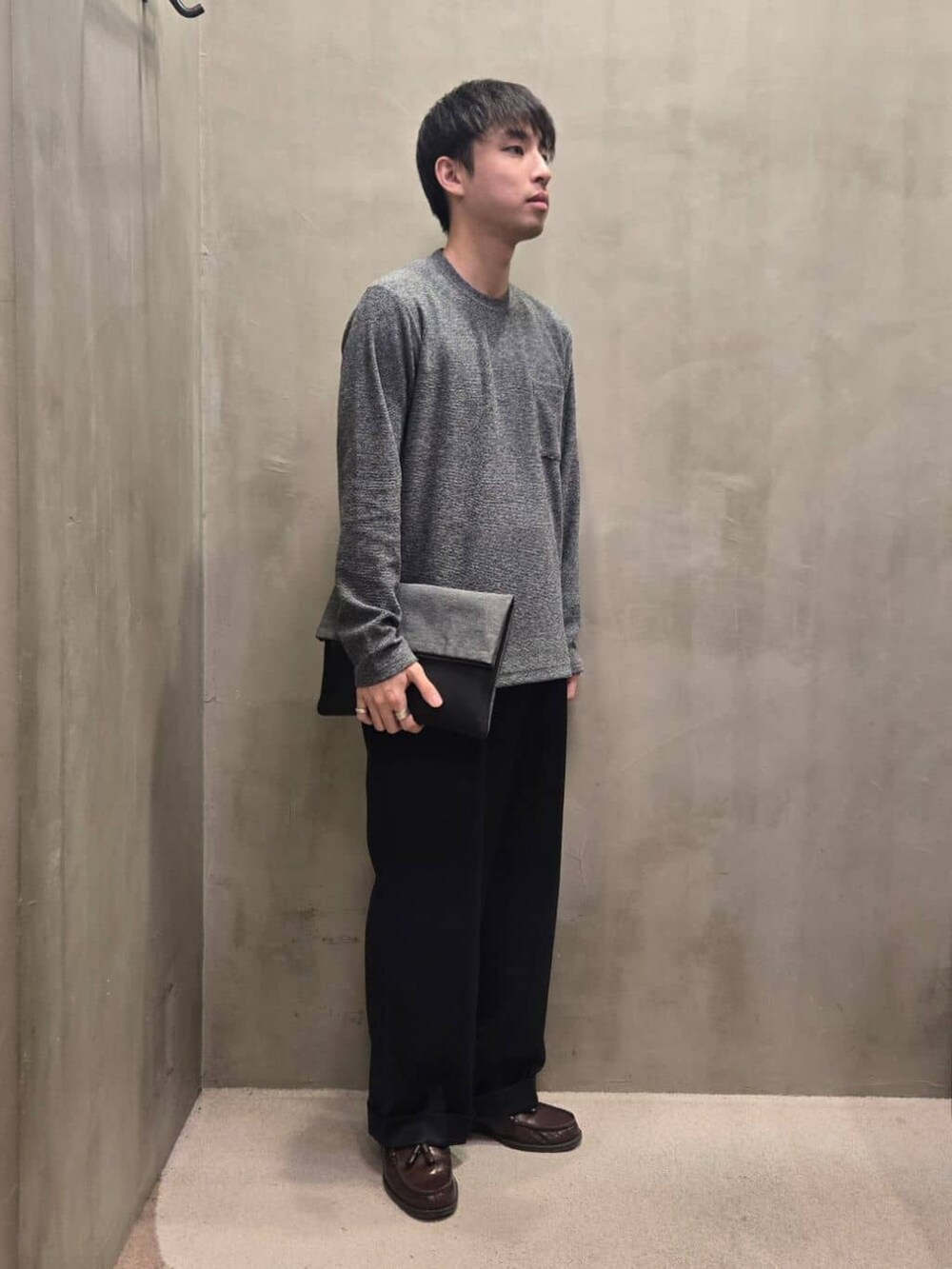 グレー系のクラッチバッグを着用したメンズの冬コーディネートの2枚目の写真