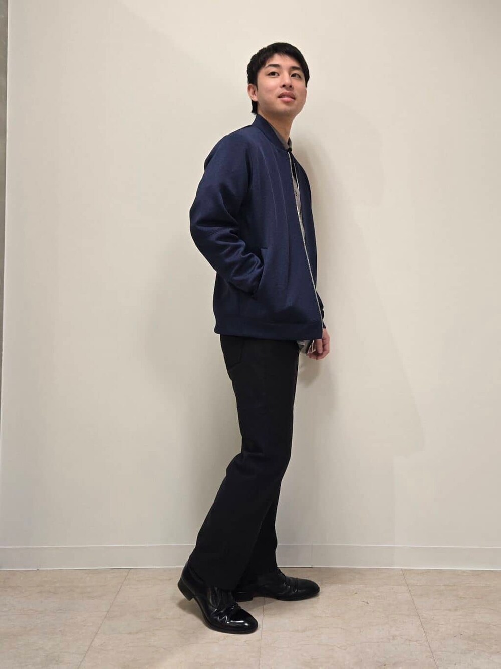 ブラック系のスラックス、ブラック系のドレスシューズを着用したメンズの冬コーディネートの2枚目の写真