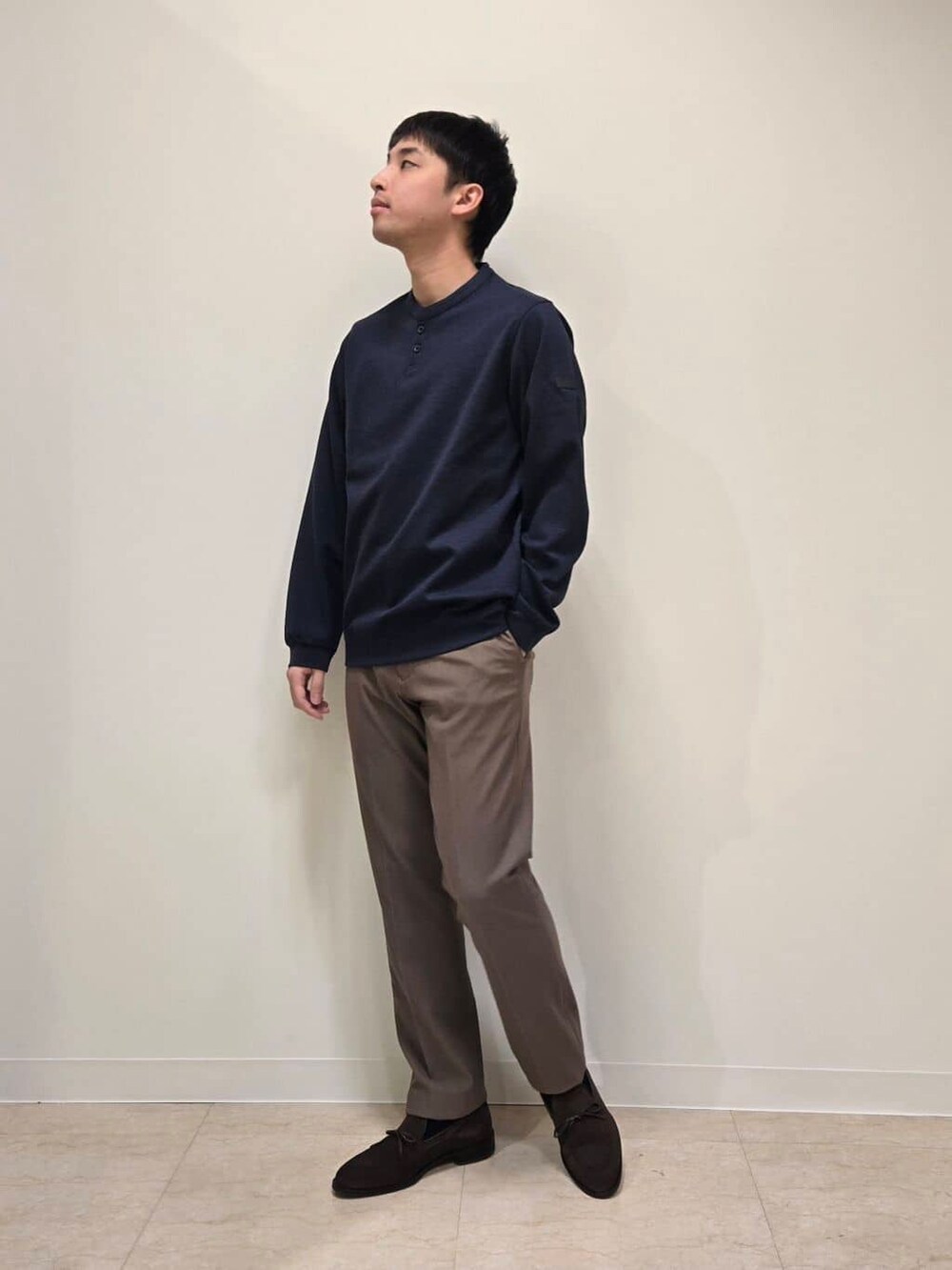 ベージュ系のスラックス、ブラウン系のドレスシューズを着用したメンズの冬コーディネートの6枚目の写真