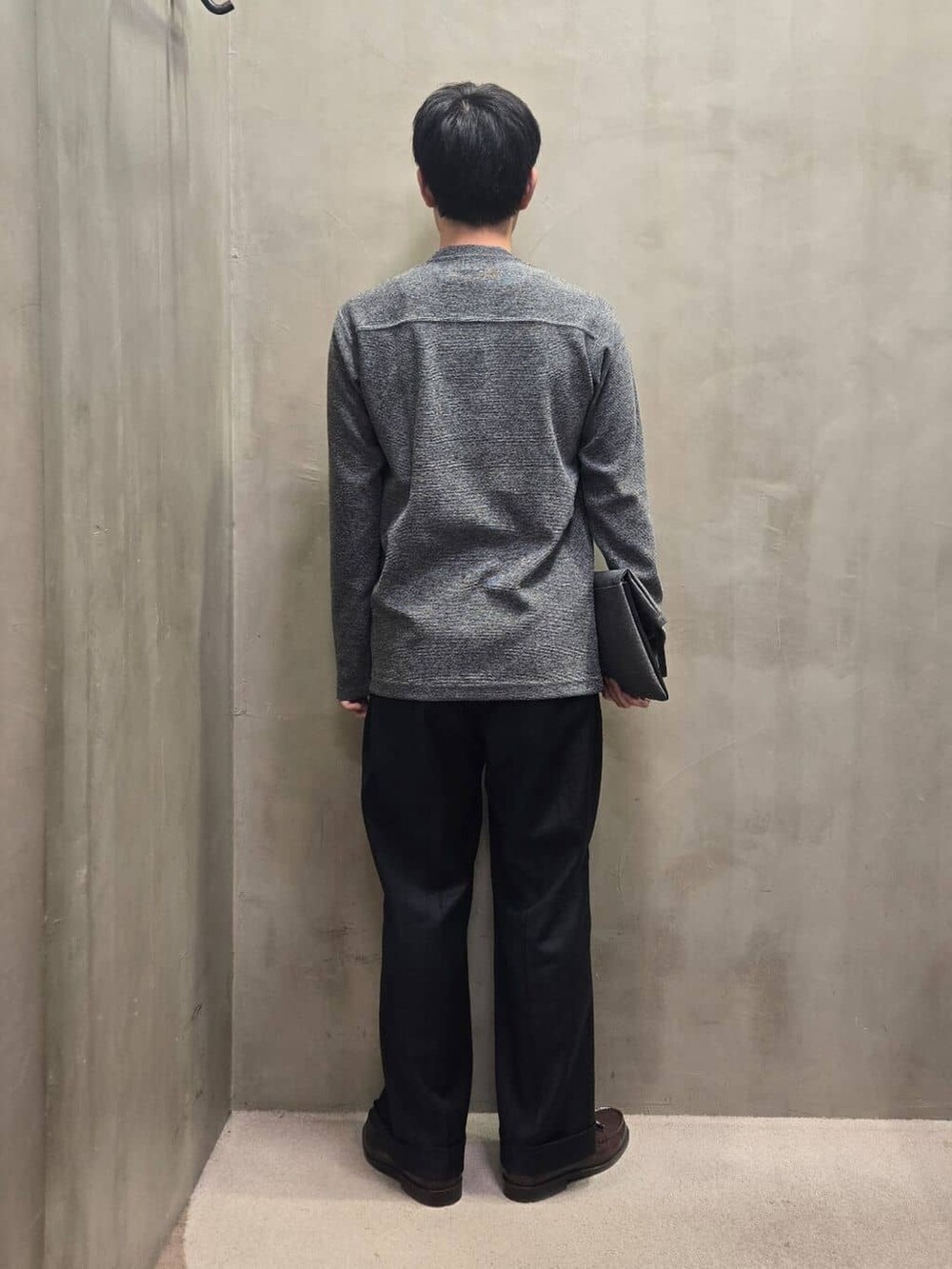 グレー系のクラッチバッグを着用したメンズの冬コーディネートの3枚目の写真