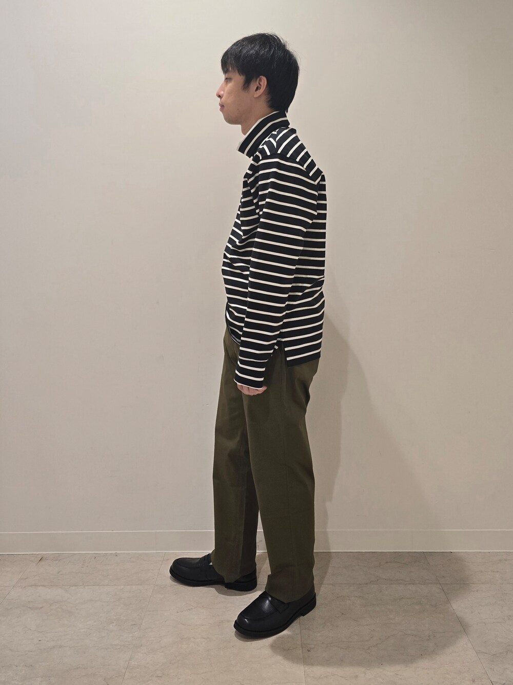 グリーン系のスラックス、ブラック系のTシャツ/カットソー、ブラック系のドレスシューズを着用したメンズの秋コーディネートの5枚目の写真