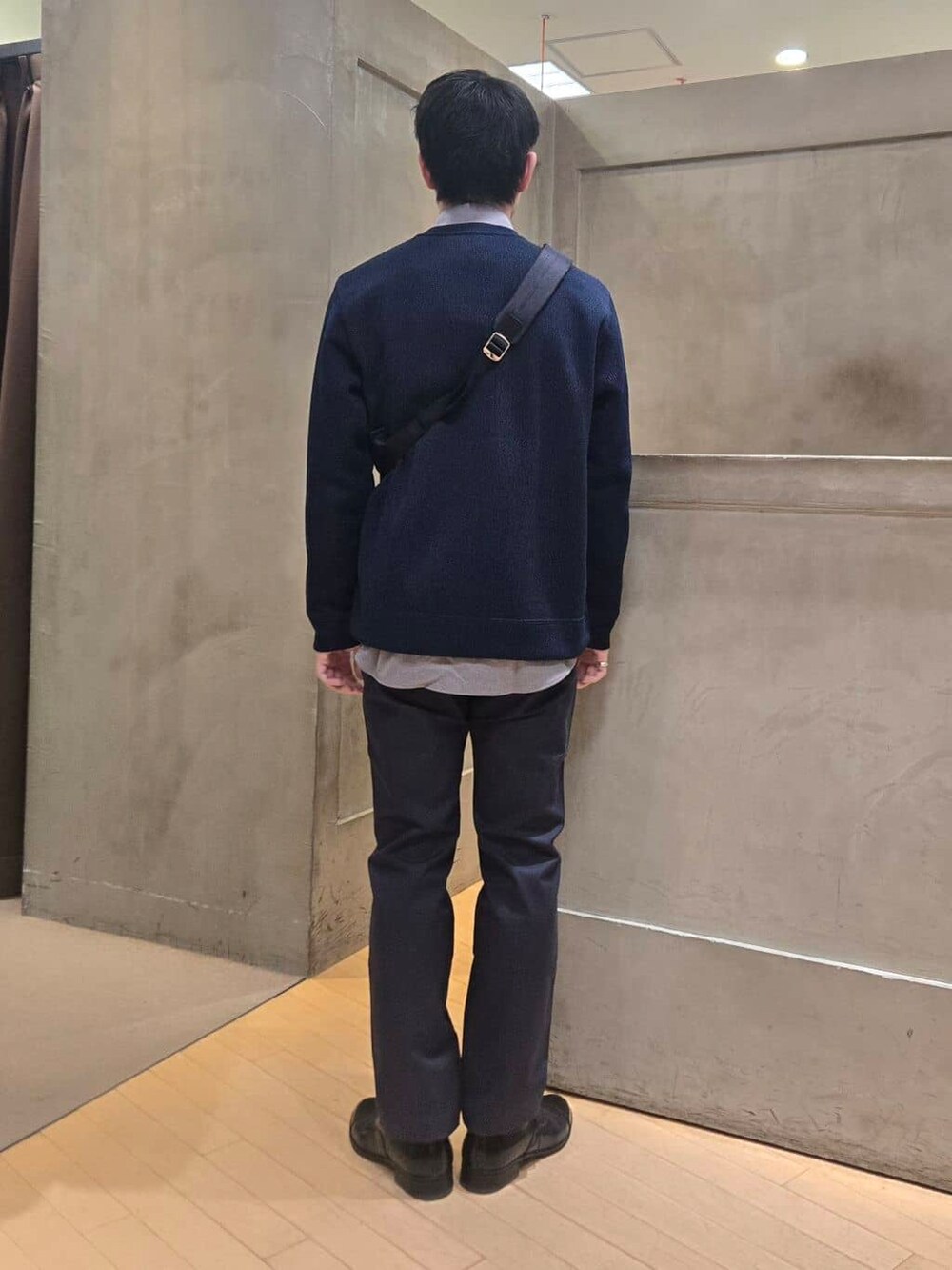 ブルー系のスラックス、ブラック系のドレスシューズ、ブルー系のショルダーバッグを着用したメンズの冬コーディネートの4枚目の写真