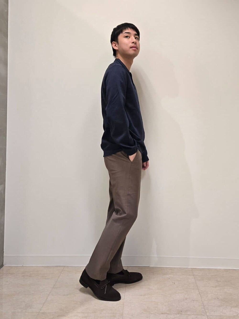 ベージュ系のスラックス、ブラウン系のドレスシューズを着用したメンズの冬コーディネートの7枚目の写真
