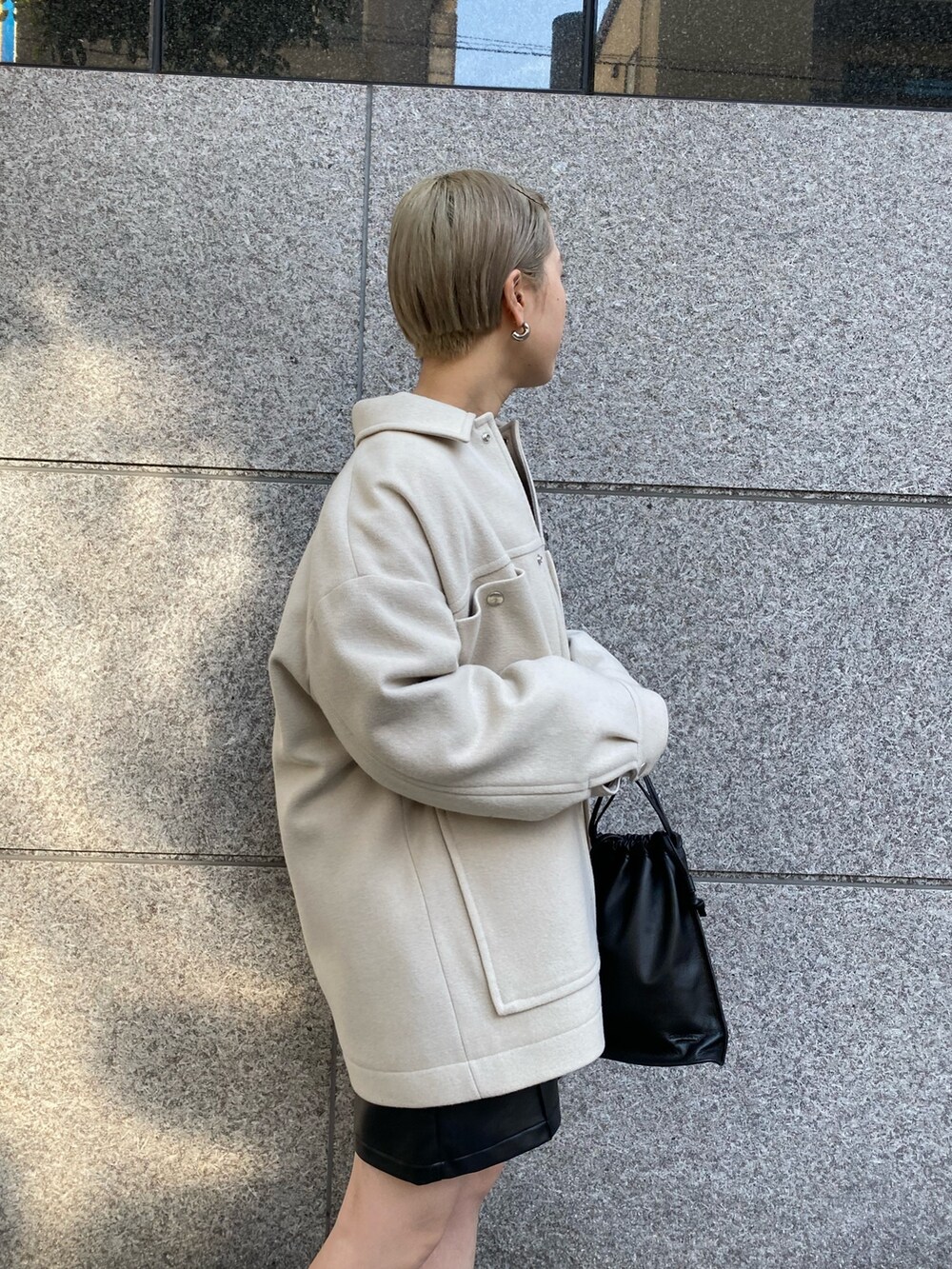 ベージュ系のブルゾン、ブラック系のその他パンツ、グレー系のマフラーを着用したレディースの秋コーディネートの4枚目の写真