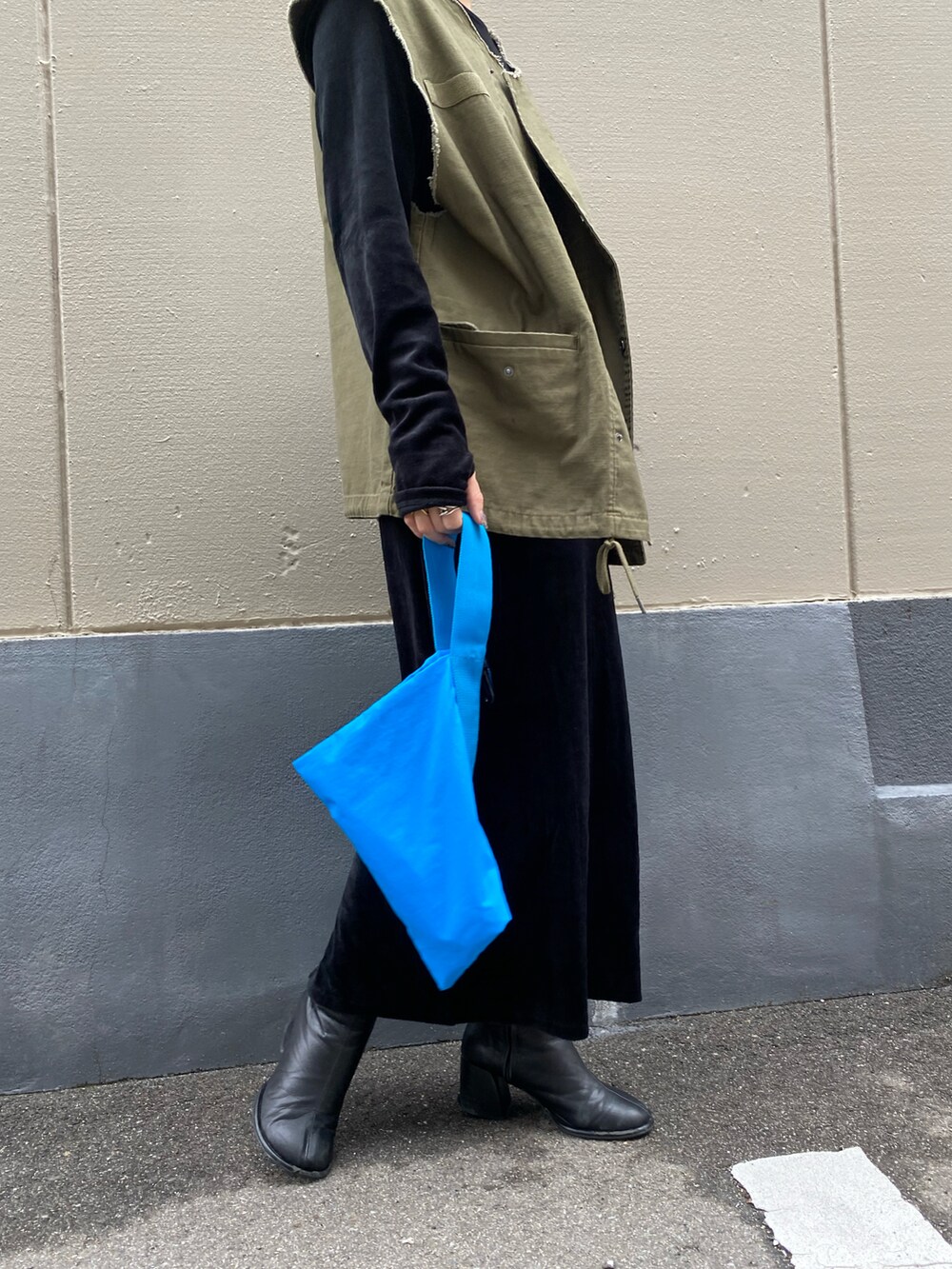 グリーン系のベストを着用したレディースの秋コーディネートの4枚目の写真