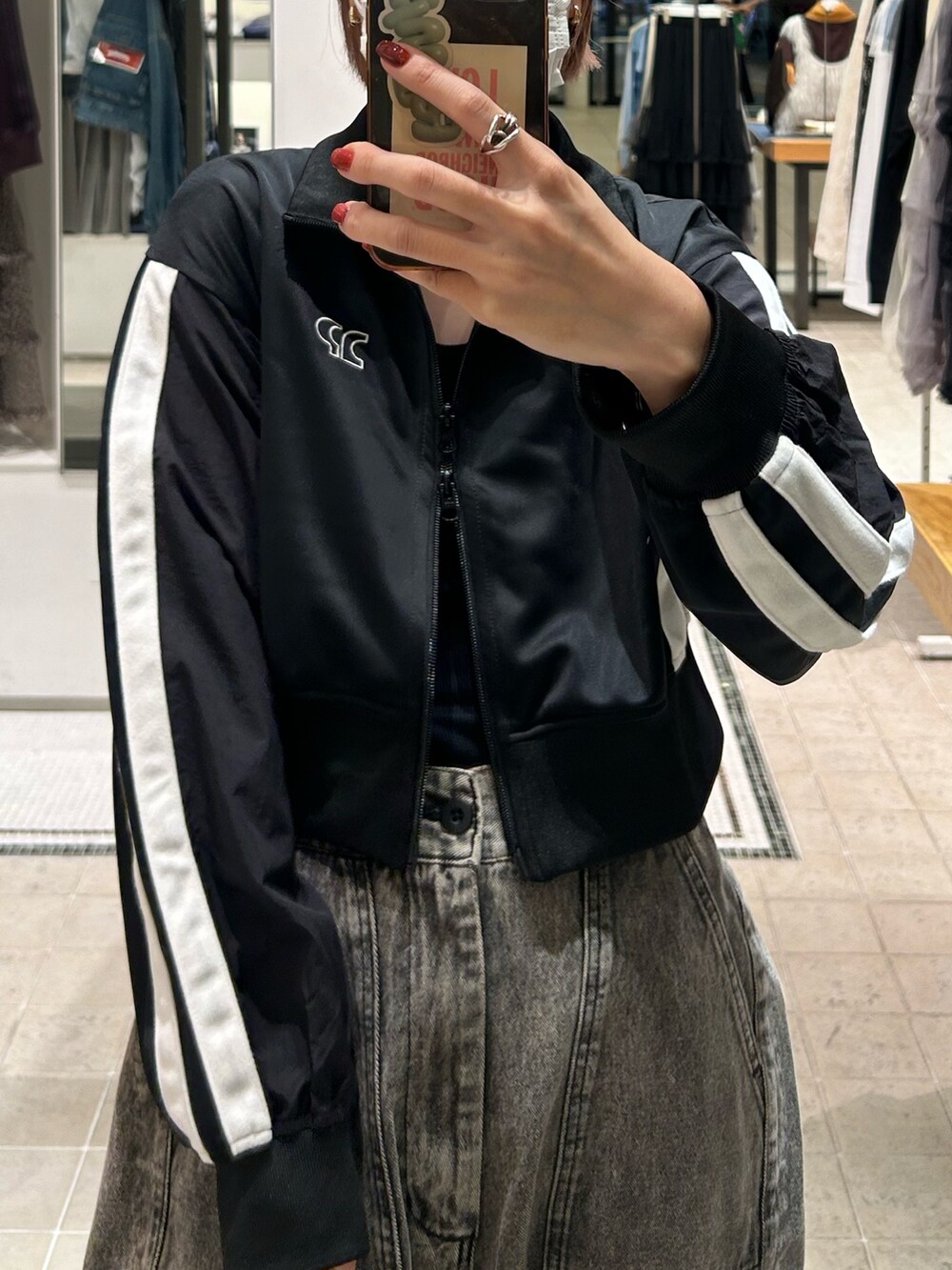 ブラック系のジャージ、ベージュ系のデニムパンツ、ブラウン系のショルダーバッグを着用したレディースの秋コーディネートの2枚目の写真