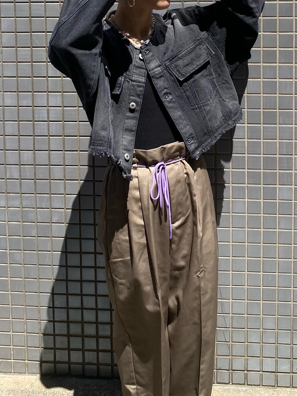 ブラック系のデニムジャケット、グレー系のチノパンツを着用したレディースの夏コーディネートの2枚目の写真