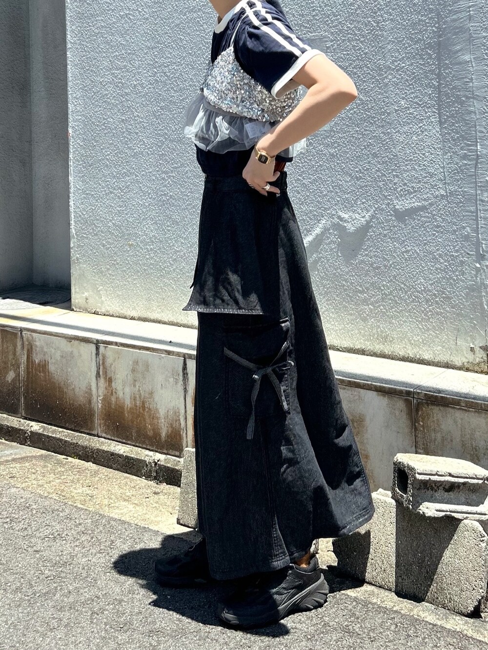 ブラック系のデニムスカート、ブルー系のTシャツ/カットソー、グレー系のキャミソールを着用したレディースの夏コーディネートの3枚目の写真