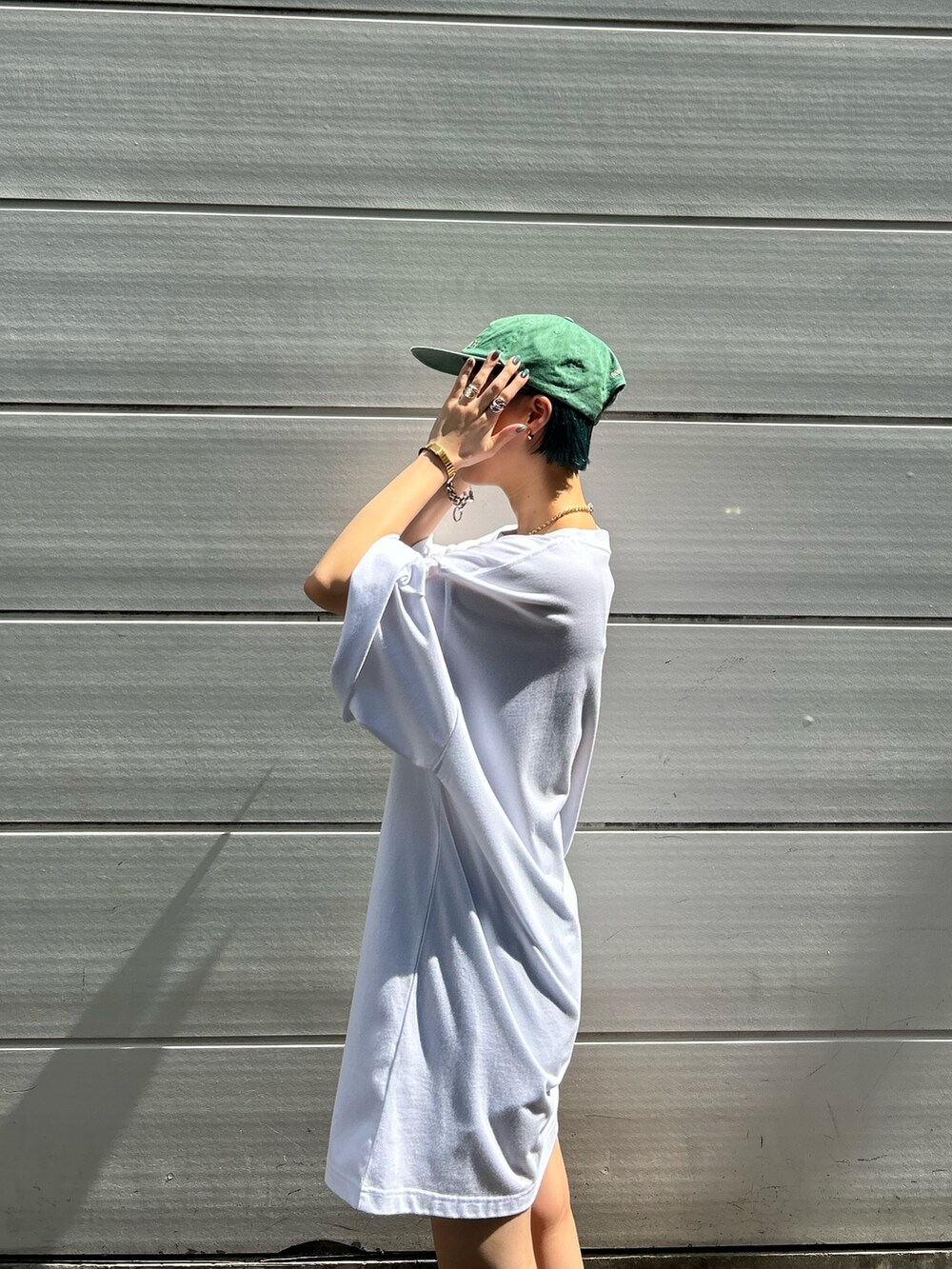 ホワイト系のTシャツ/カットソー、グリーン系のキャップを着用したレディースの夏コーディネートの3枚目の写真