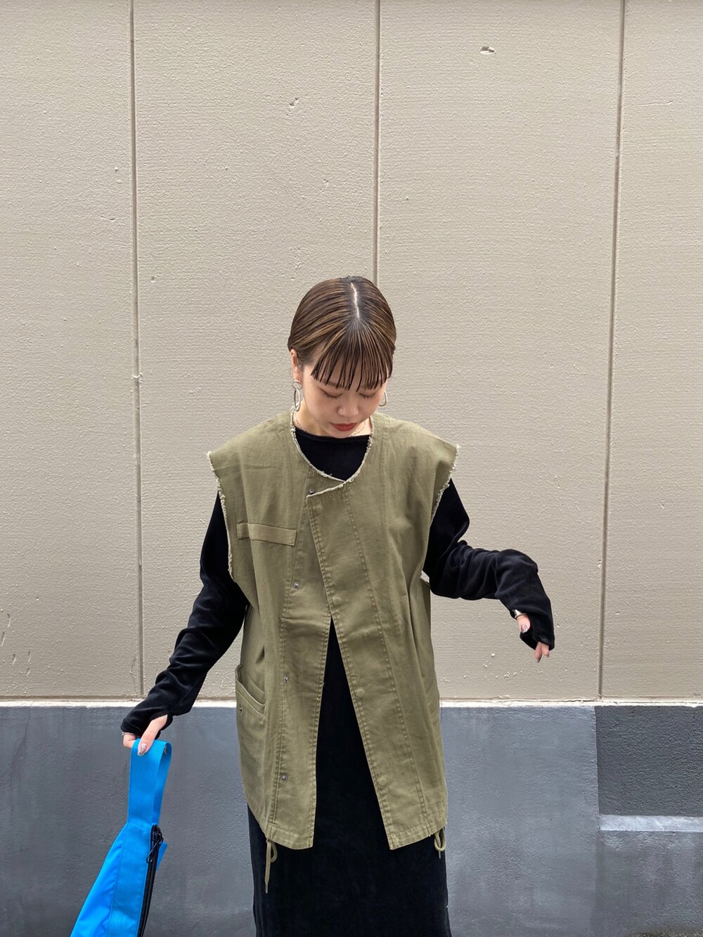 グリーン系のベストを着用したレディースの秋コーディネートの3枚目の写真