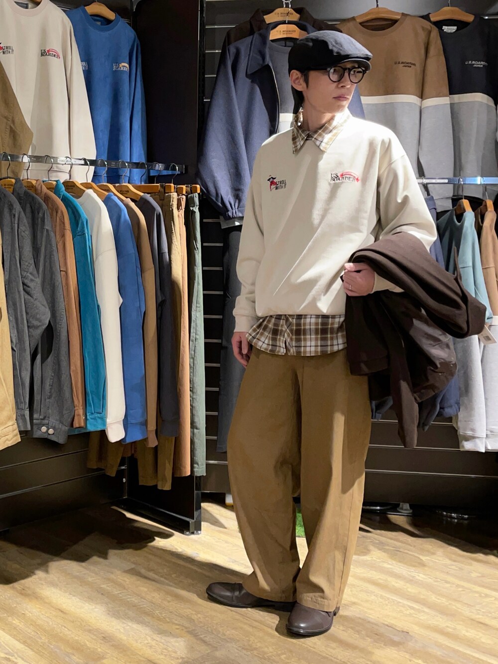 ホワイト系のスウェット、ブラウン系のブルゾン、ベージュ系のデニムパンツを着用したメンズの春コーディネートの2枚目の写真