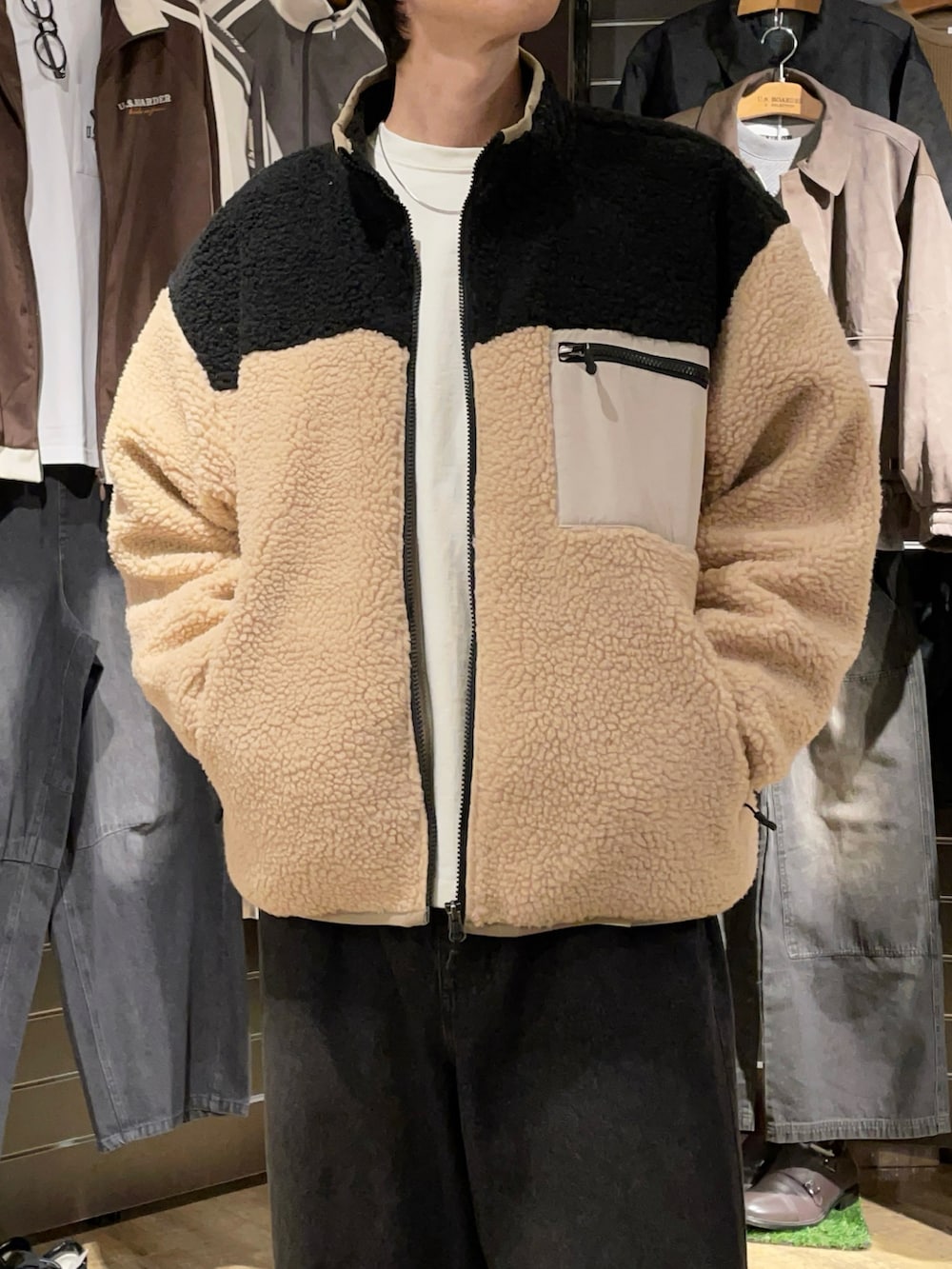 ベージュ系のブルゾン、ブラック系のデニムパンツ、ブラウン系のスニーカーを着用したメンズの秋コーディネートの2枚目の写真