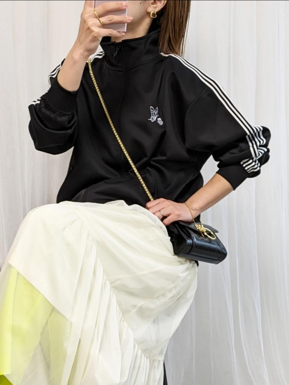 ブラック系のジャージ、ブラック系のバッグ、グリーン系のその他パンツを着用したレディースの春コーディネートの2枚目の写真