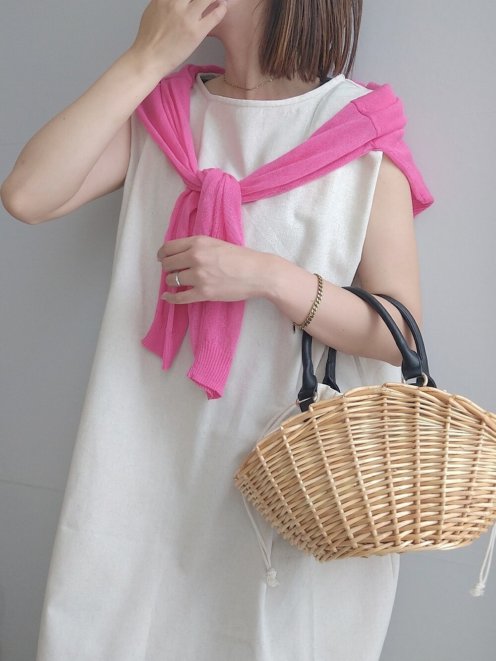 ベージュ系のバッグ、ピンク系のカーディガン/ボレロ、ホワイト系のワンピースを着用したレディースの春コーディネートの4枚目の写真