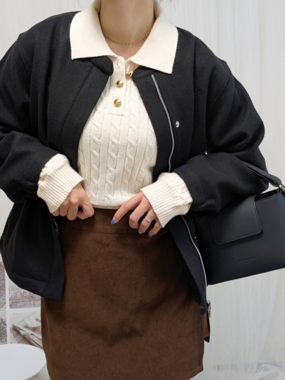 ブラック系のノーカラージャケット、ホワイト系のニット/セーター、ブラック系のショルダーバッグを着用したレディースの秋コーディネートの3枚目の写真