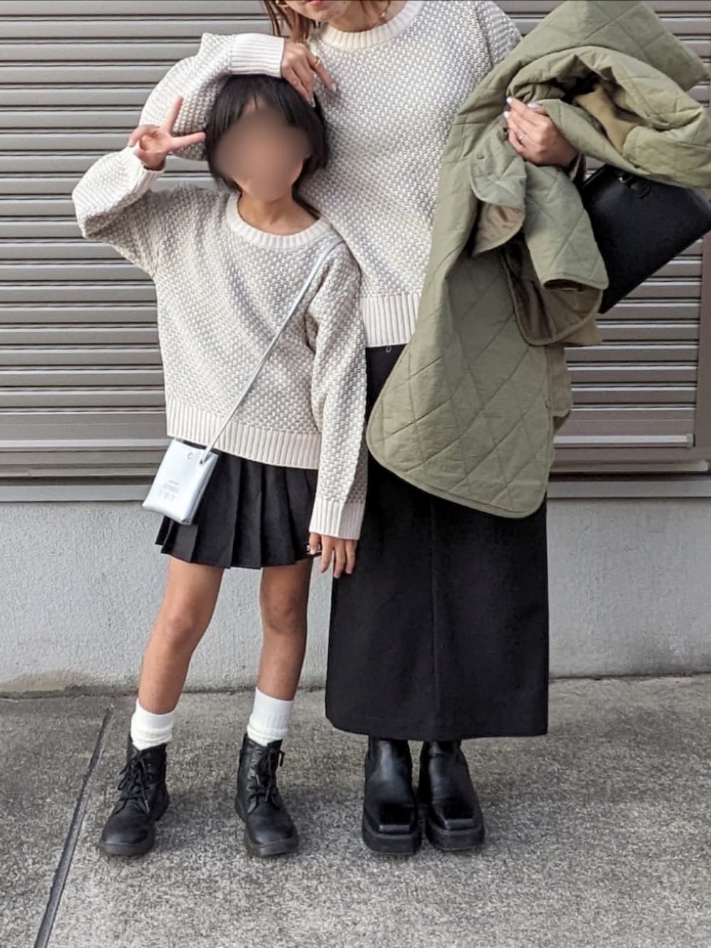 ブラック系のブーツ、グリーン系のニット/セーター、グリーン系のブルゾンを着用したキッズの秋コーディネートの3枚目の写真